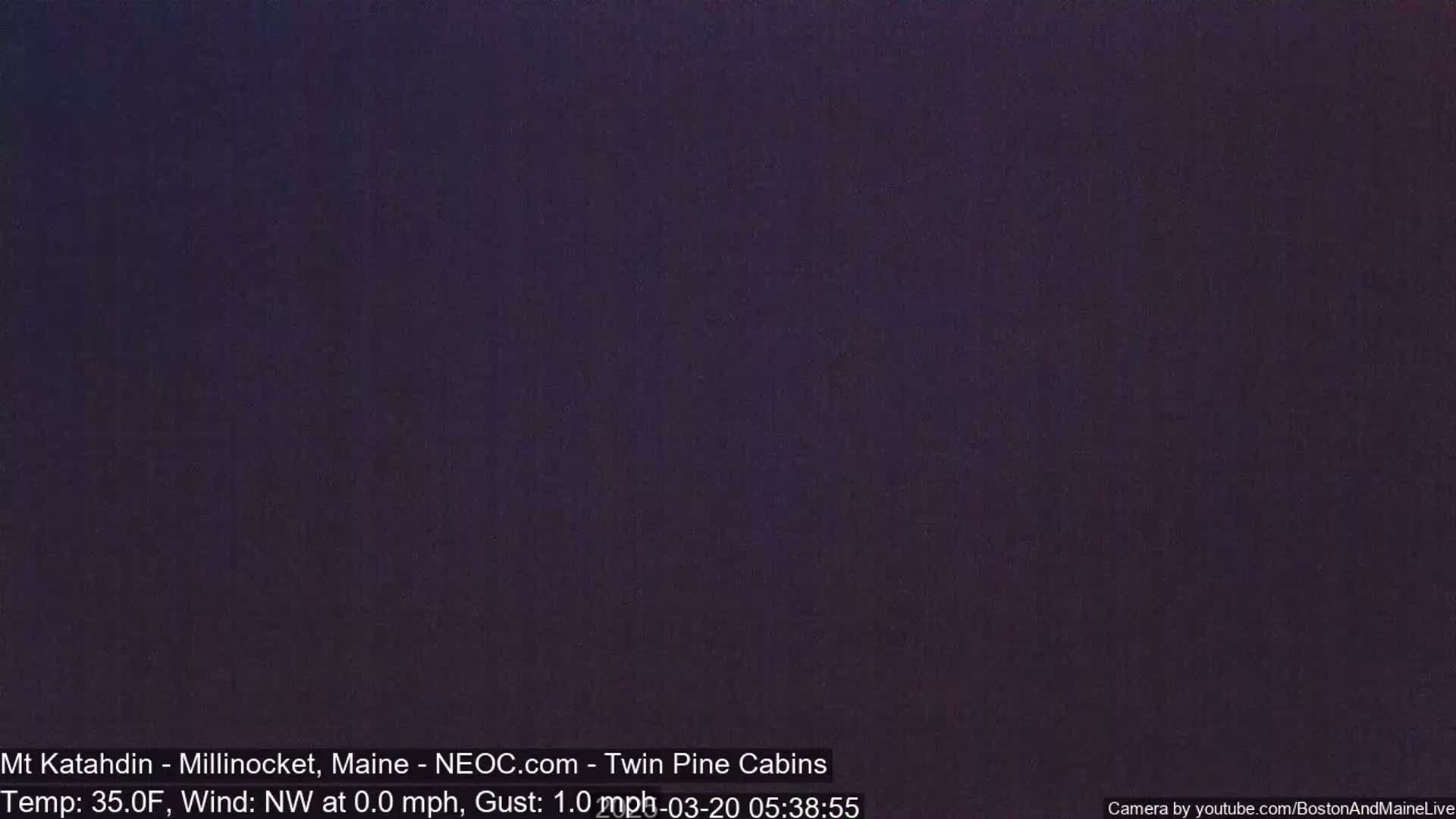 A dark, nighttime image shows a uniformly colored, dark purple-gray sky.