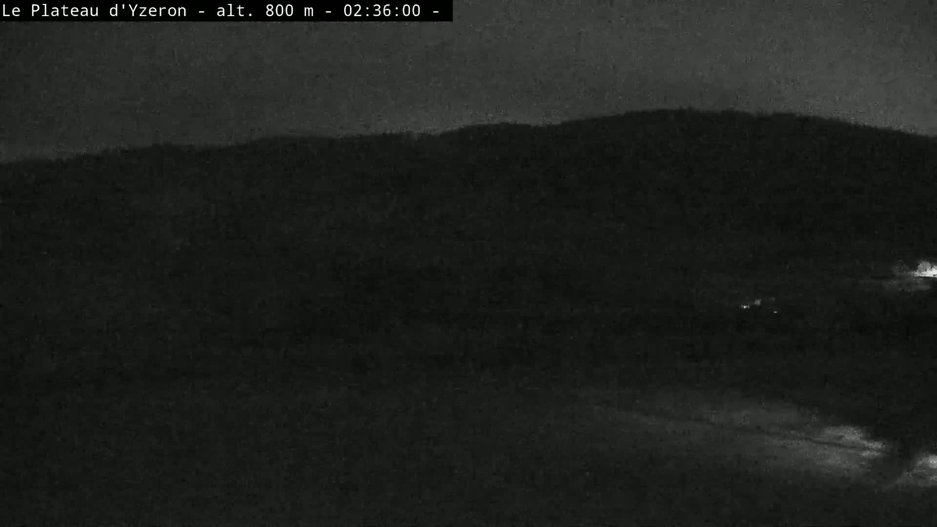 A nighttime, dark view of a hilly landscape.