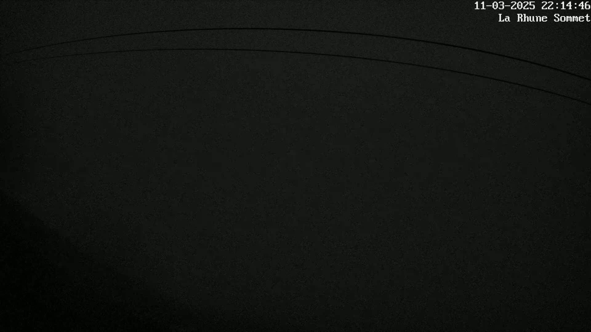 A dark, nighttime image shows two thin, parallel lines arcing across a mostly black background.