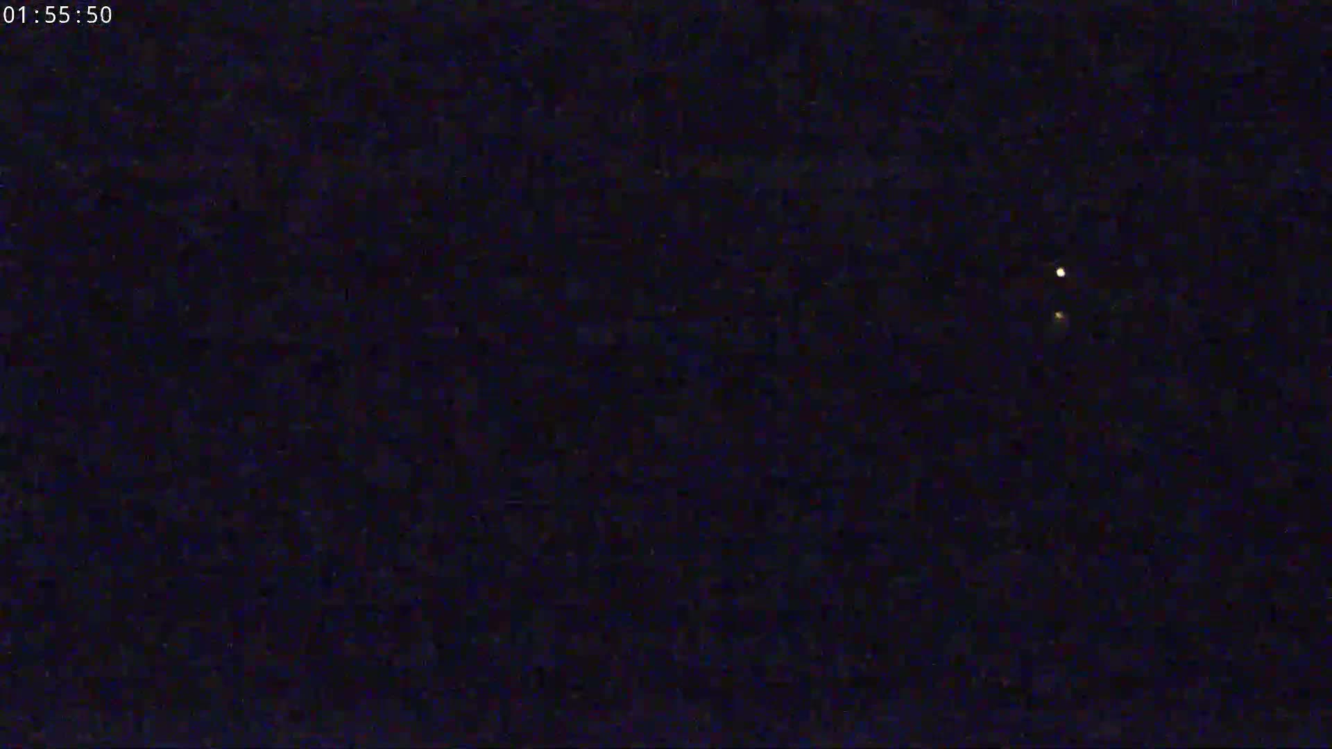 The image shows two faint lights in a dark night sky.