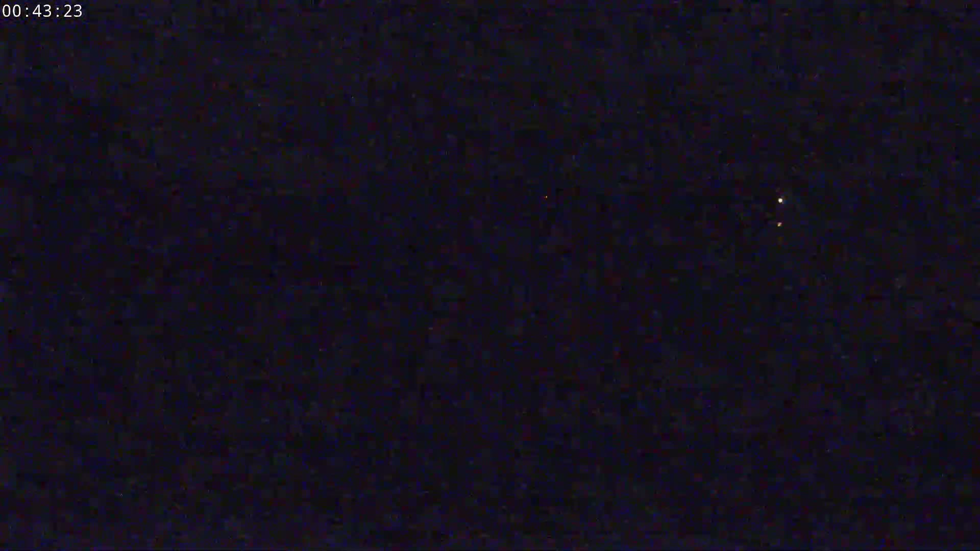 A dark night sky shows a few faint, distant lights.