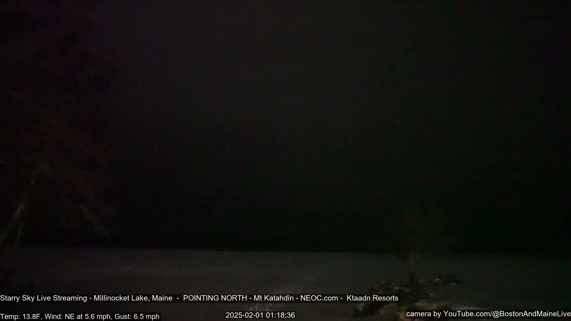 A dark, nighttime scene shows a body of water under a mostly clear, starry sky with a gentle northeasterly wind.