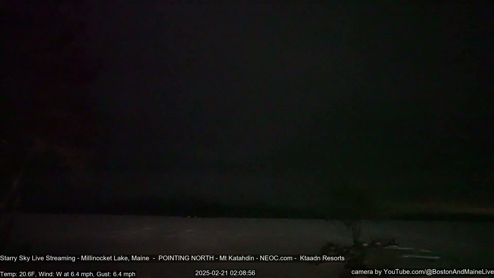 A dark, starry night scene over a body of water with a slight wind.