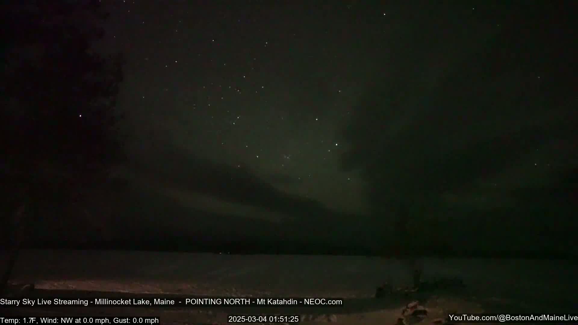 A dark, starry night sky over a calm body of water under a temperature of 1.7°F.