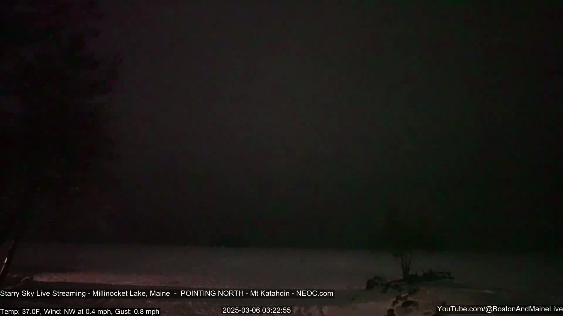 A dark, snowy landscape is visible under a nearly black night sky with a light northwest wind.