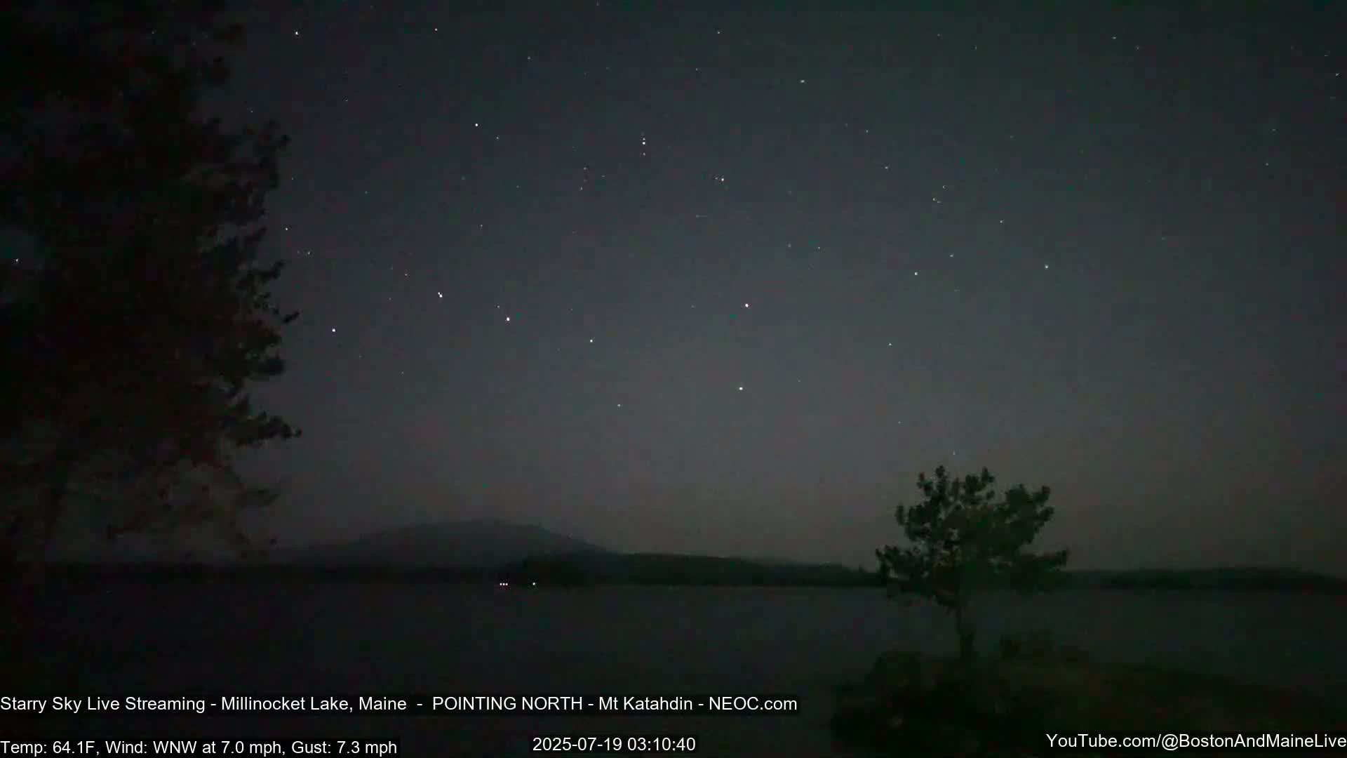 A nighttime view of a calm lake under a starry sky, with a slight wind blowing from the west-northwest.