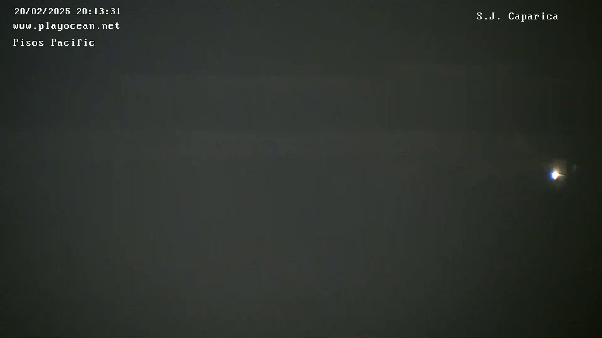 A dark, nighttime scene shows a single, small light in the distance.