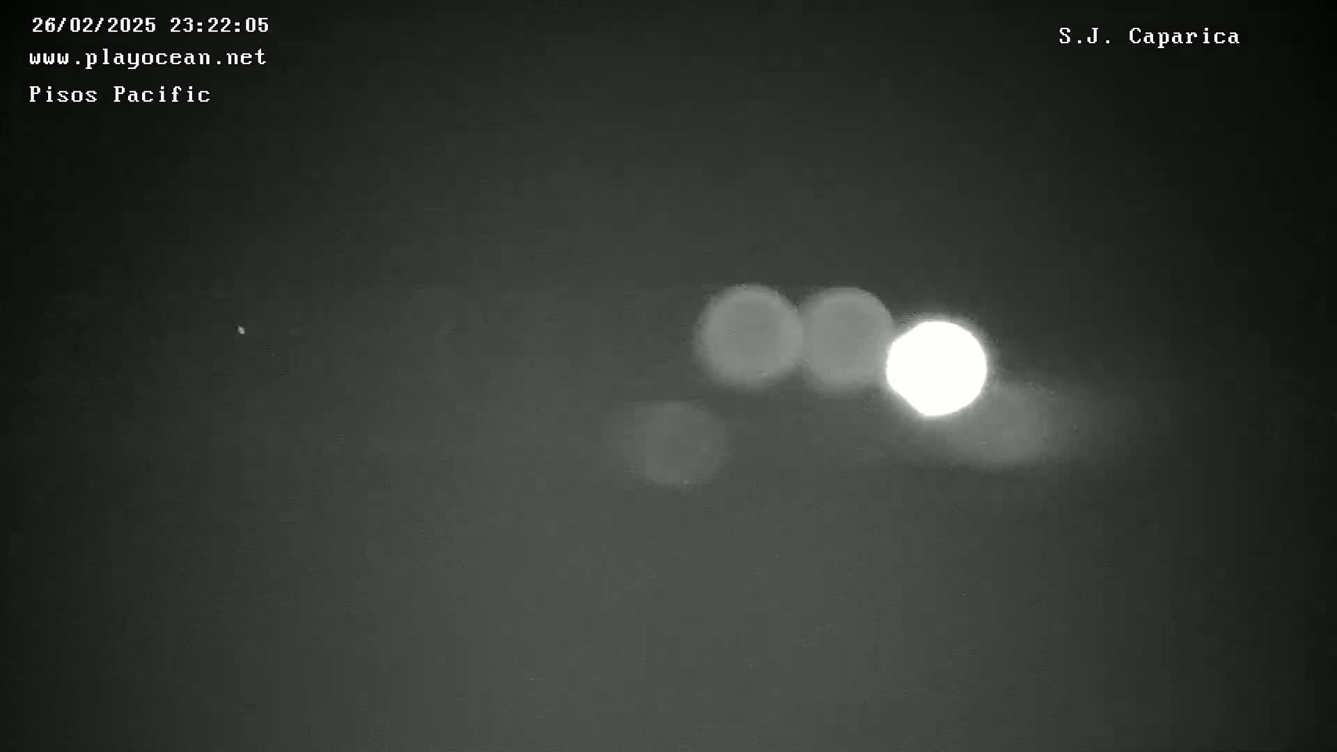 A bright light, possibly a streetlight or a distant source of illumination, is visible in a dark, nighttime sky.