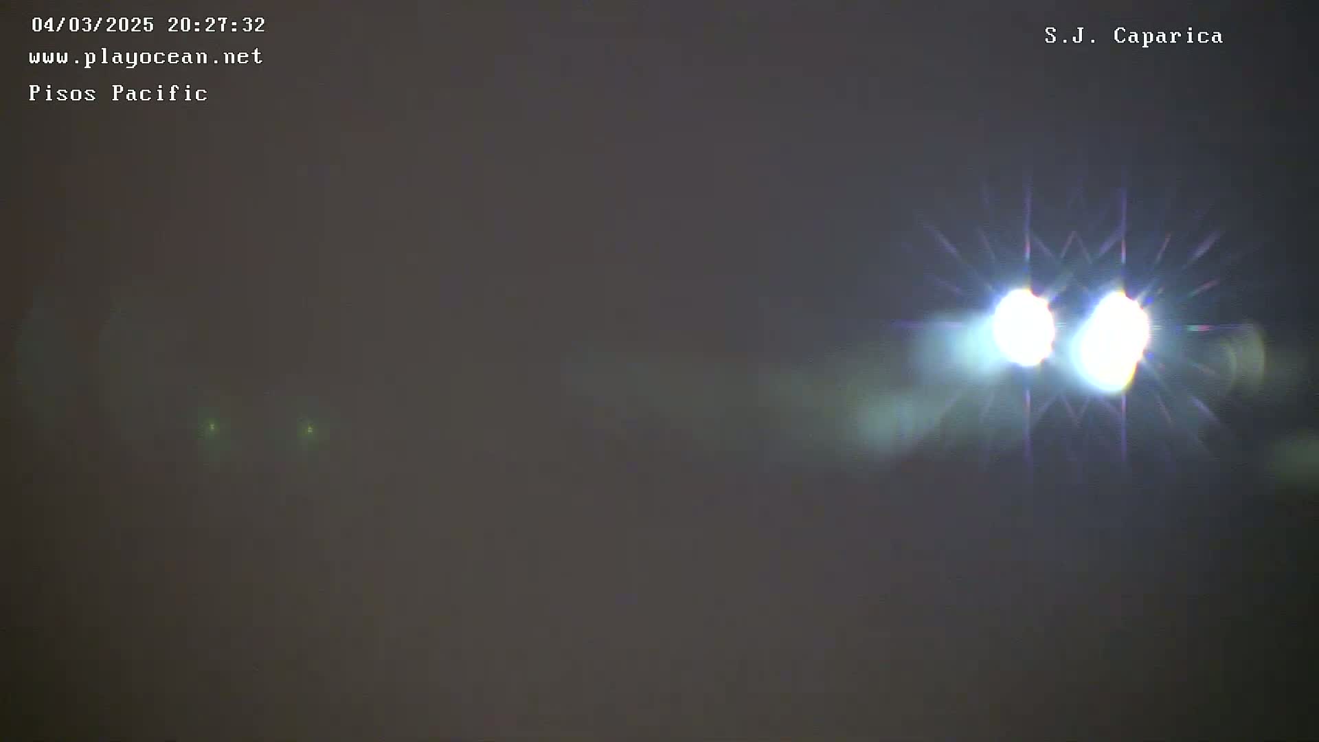 Two bright lights are visible through a hazy, dark atmosphere.