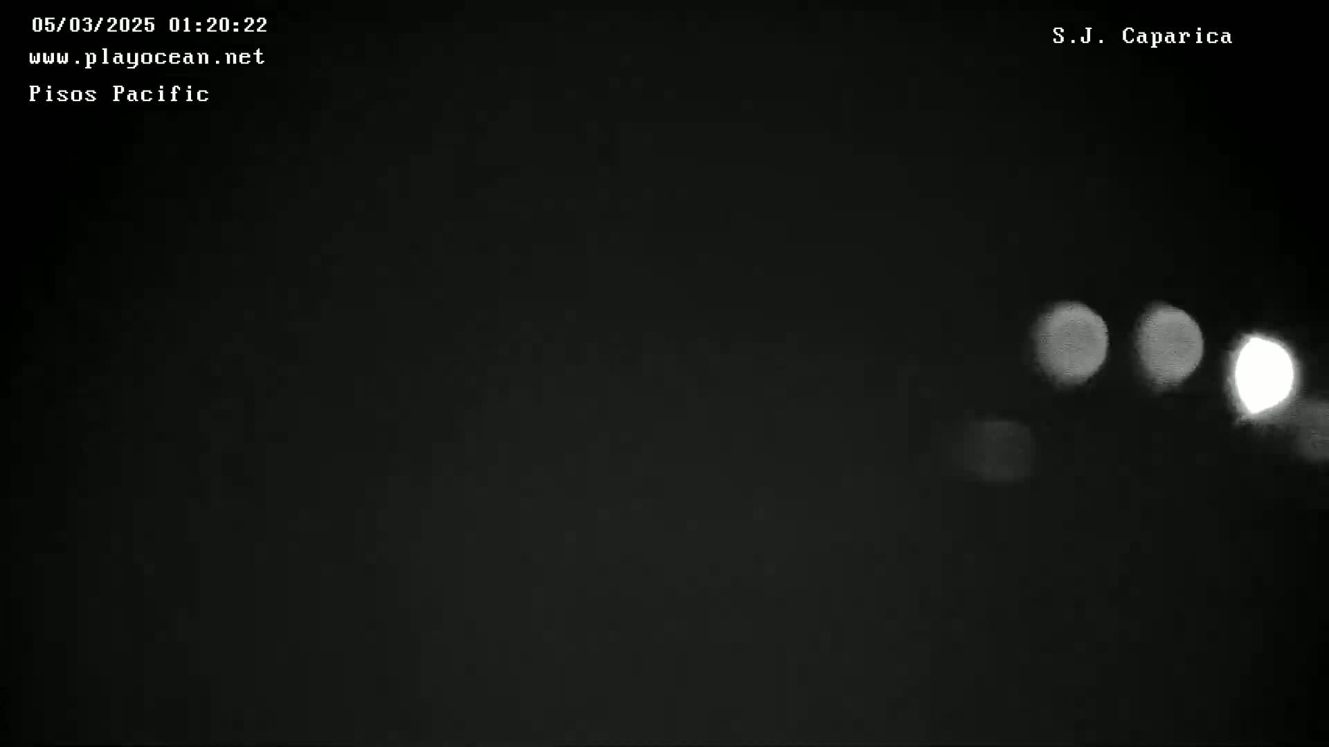At night, several blurry lights are visible against a completely dark background.