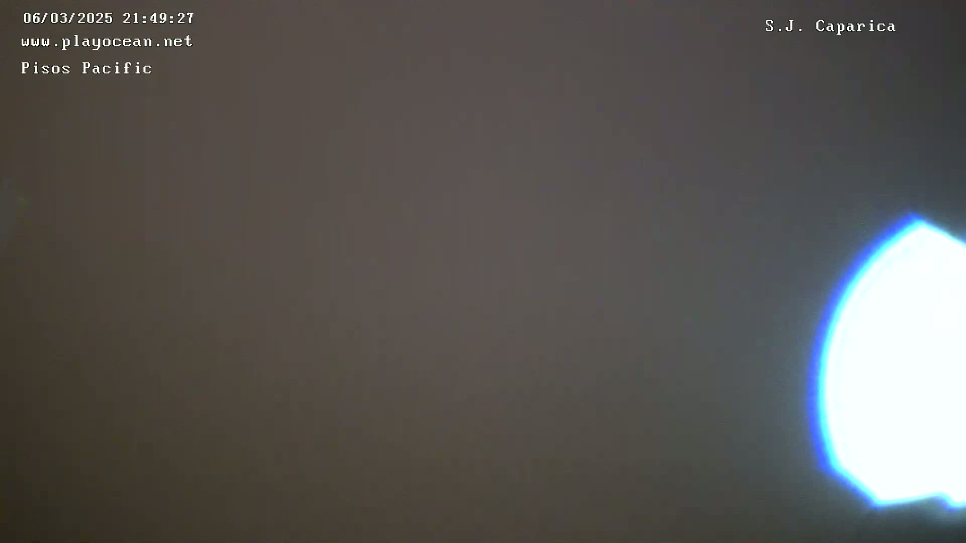 A mostly dark image shows a bright, blurry, teardrop-shaped light in the lower right corner.