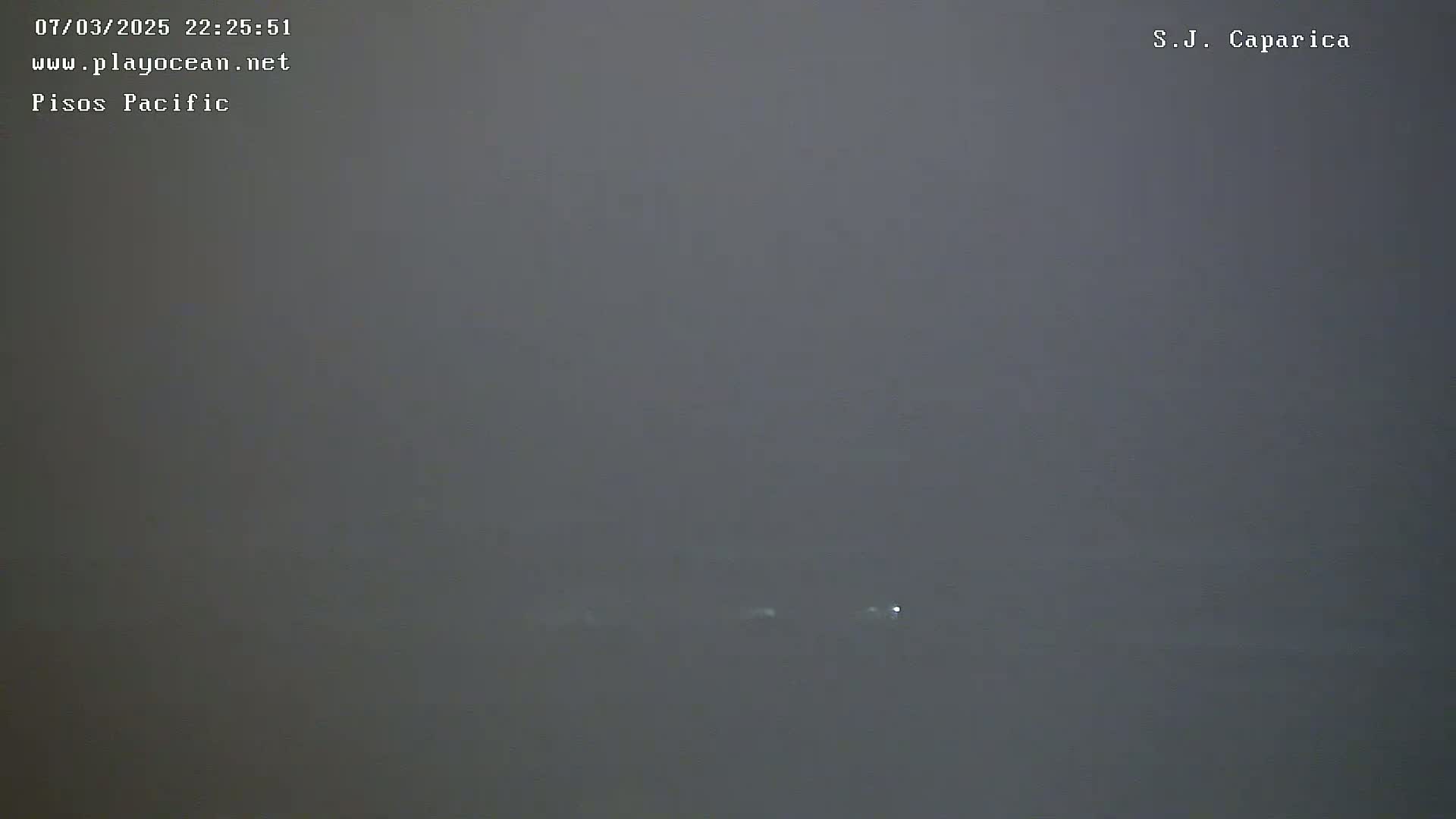 A very foggy or hazy night scene shows a few faint lights in the distance.