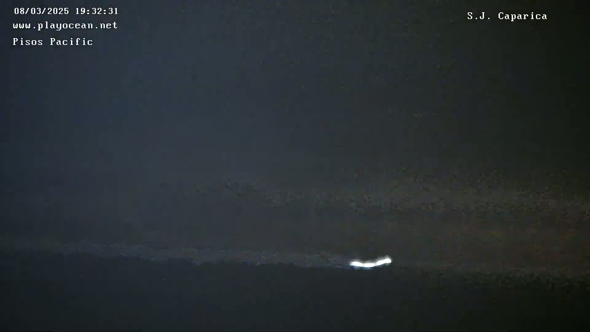 A dark, possibly nighttime, ocean scene shows a faint light on the horizon.