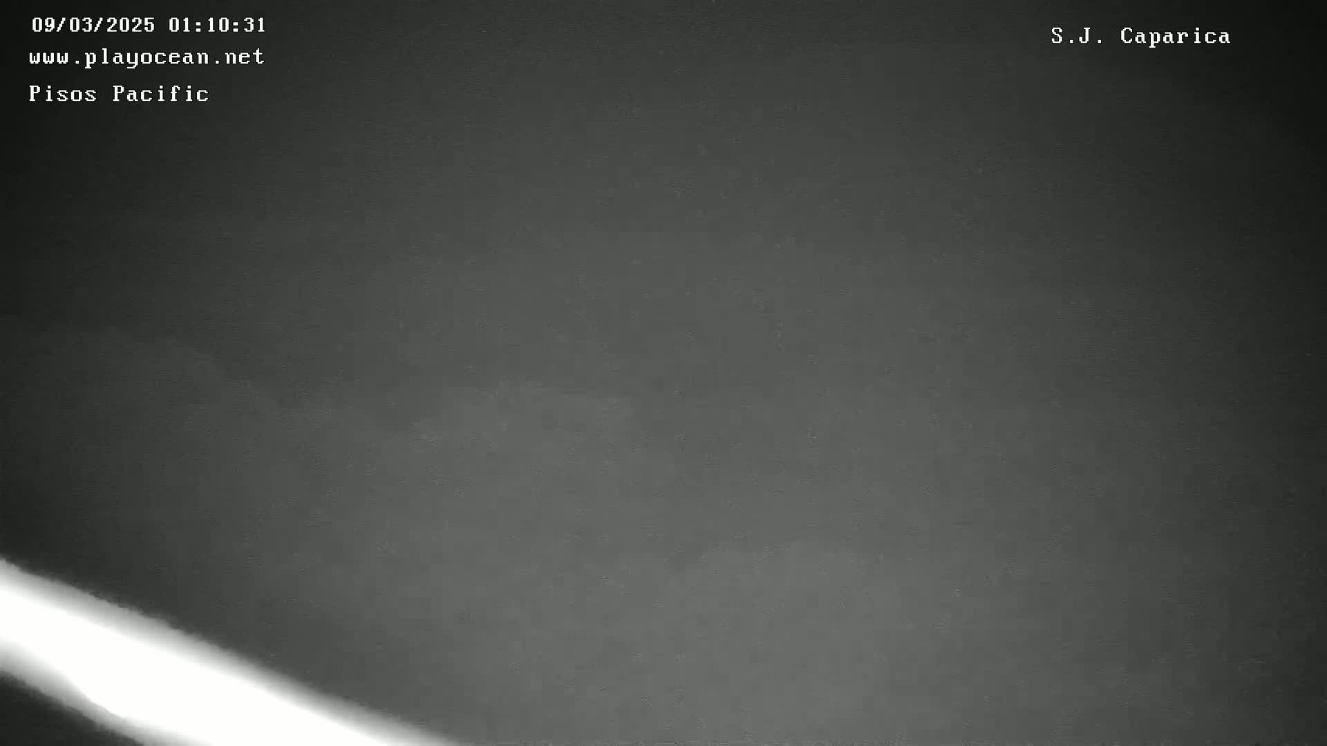 A dark, overcast night scene is shown, with a bright light streak in the bottom left corner.