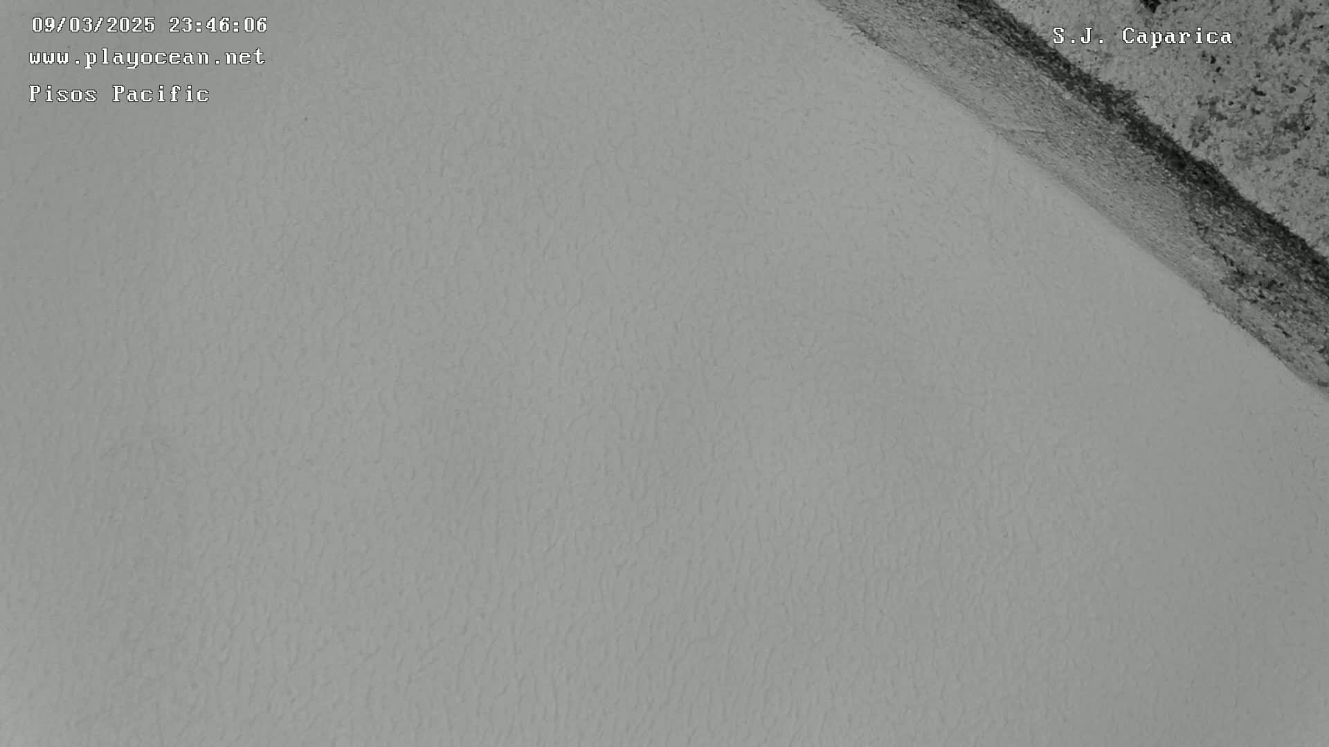 A textured, light gray surface is shown, with a darker gray area diagonally across the upper right corner.