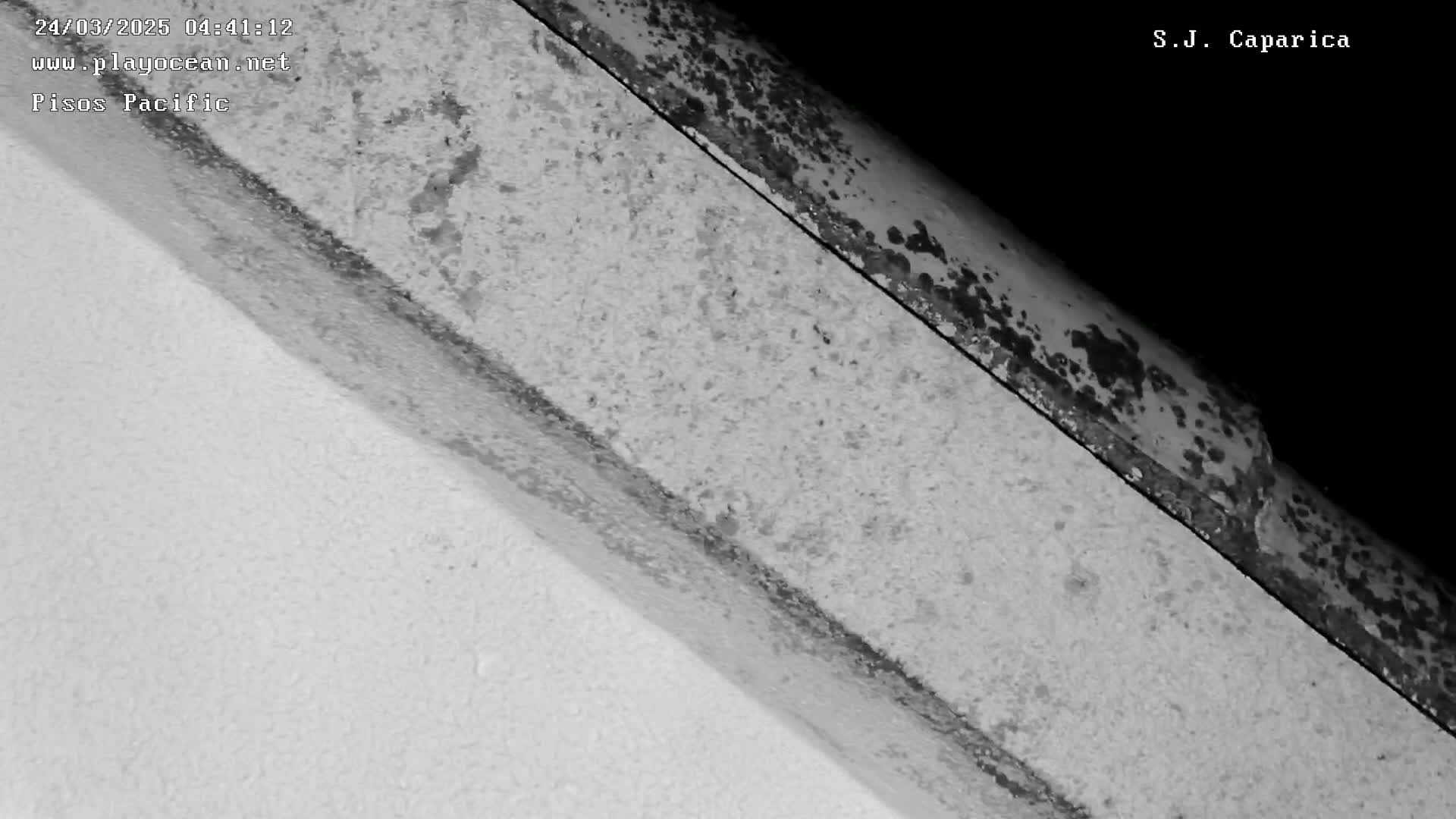 A close-up shows two textured surfaces meeting at an angle, one lighter and smoother, the other darker and rougher with dark spots.