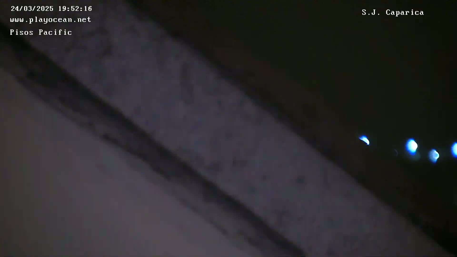 A dark, blurry image shows a diagonal gray surface with out-of-focus blue lights in the distance.