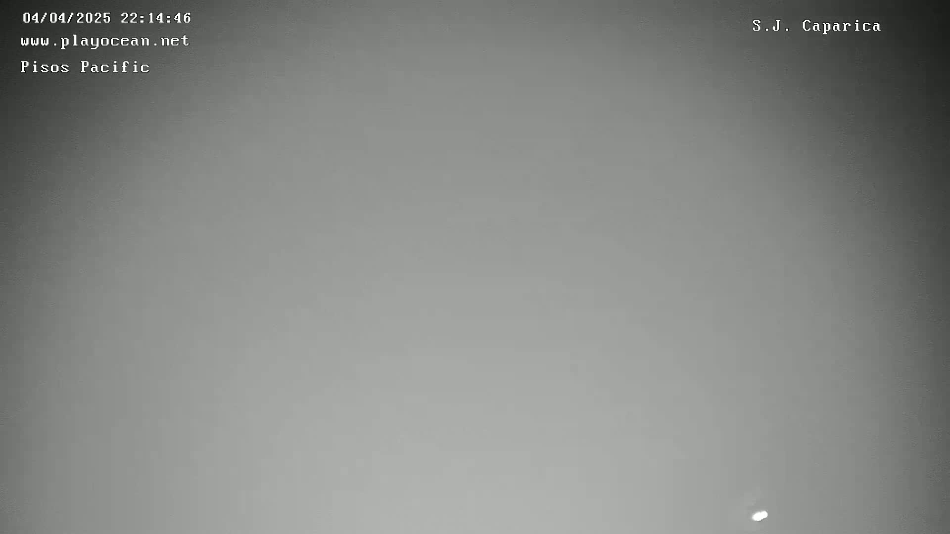 A grainy, dark gray image shows a mostly featureless night sky with a faint light source near the bottom.