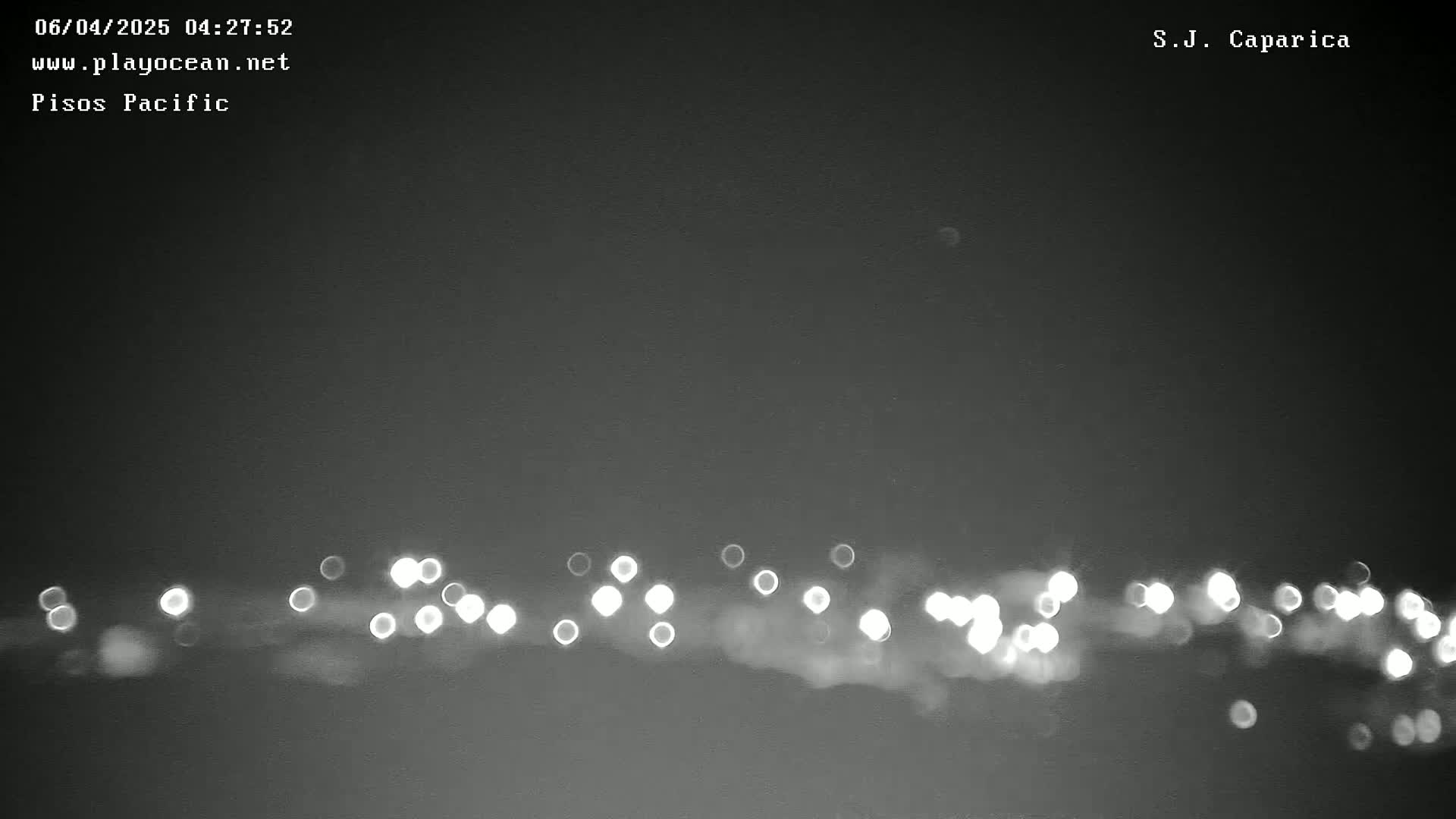 A blurry line of lights is visible at the bottom of a dark, nighttime image.