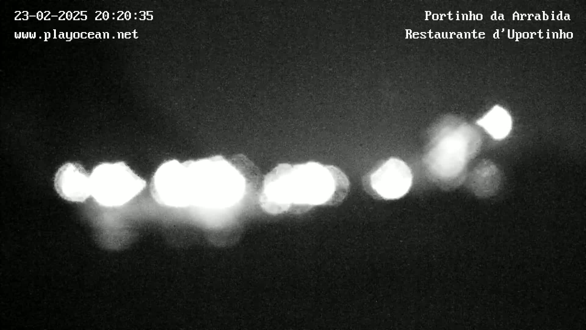 At night, several blurry white lights appear as out-of-focus points of light against a dark background.