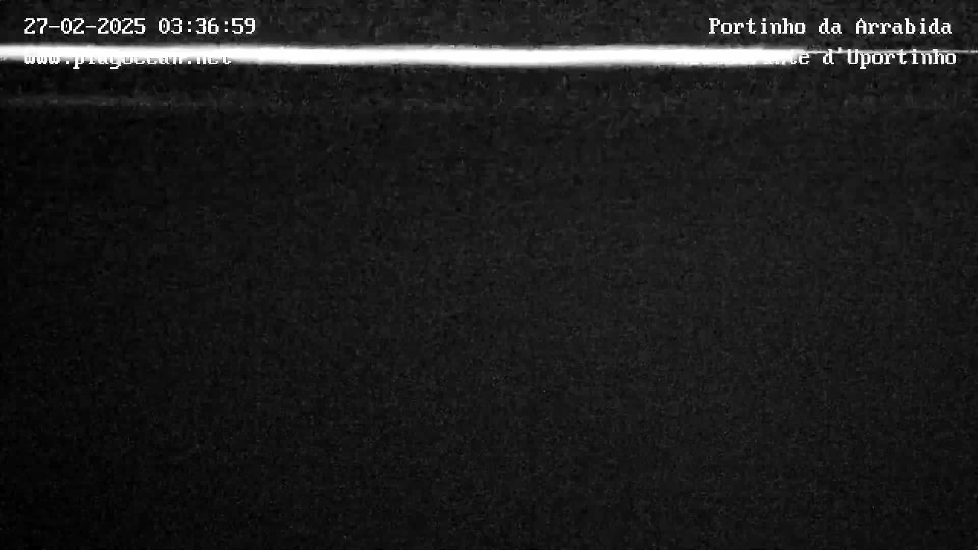 A nighttime image shows a dark, grainy surface with a thin, bright horizontal line across the top.