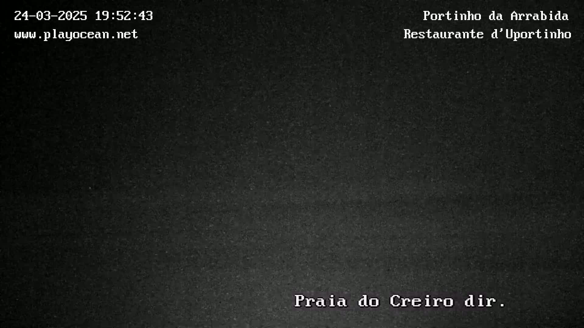 A nighttime, dark gray image shows a low-light view of a beach.
