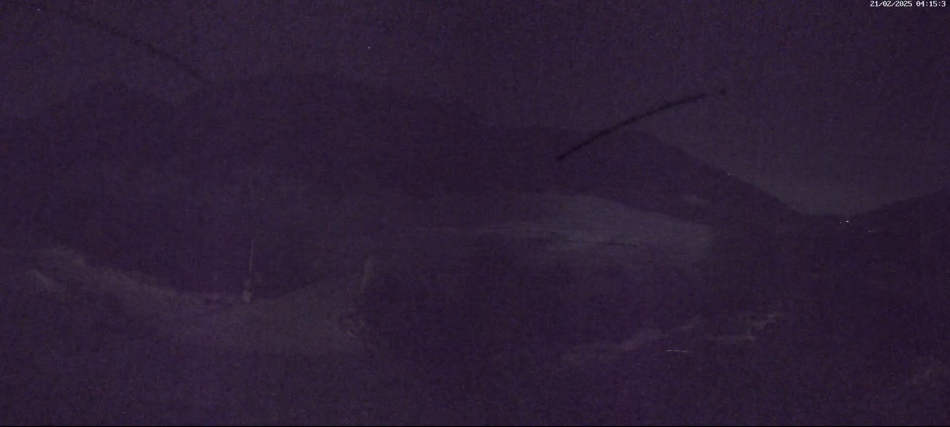 A dark, nighttime outdoor scene shows a blurry, indistinct landscape with muted lighting.