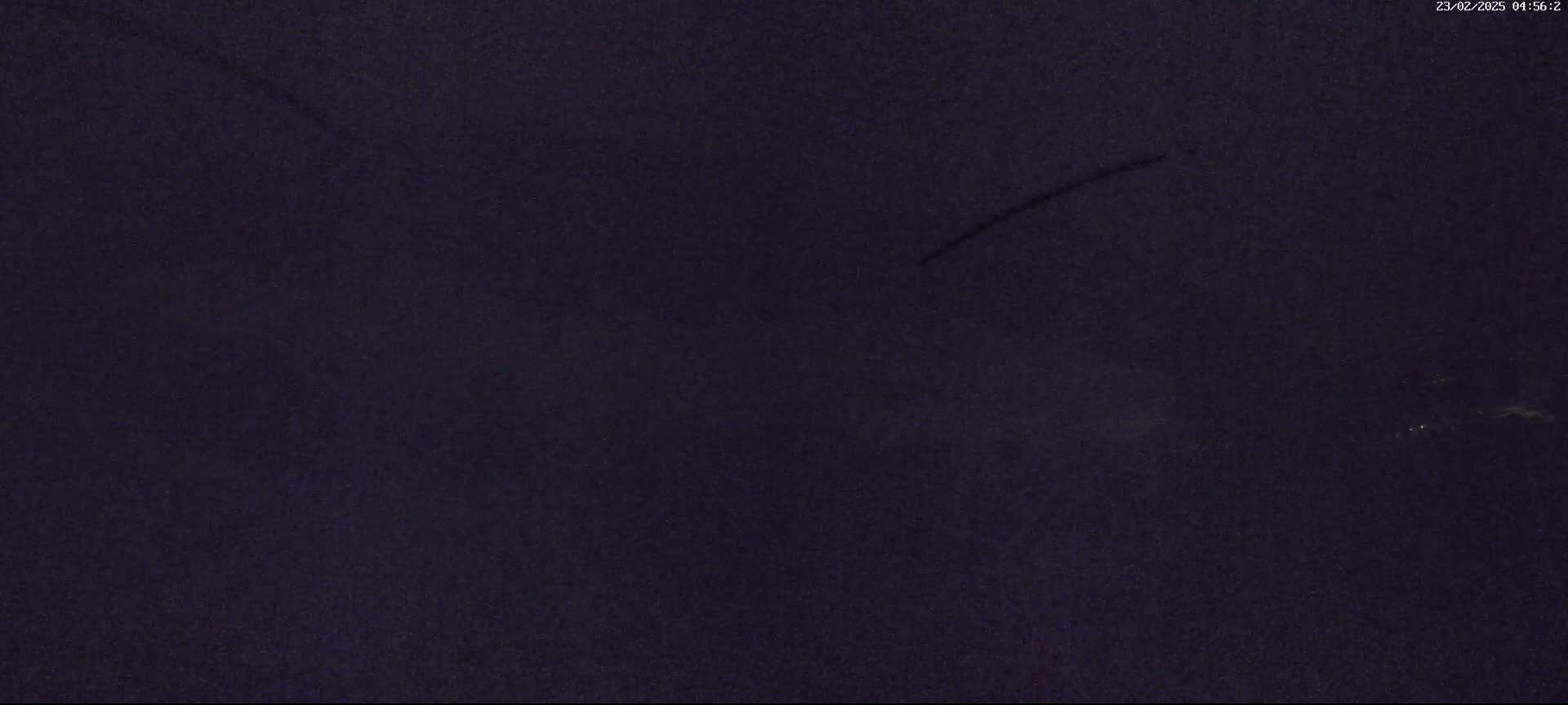 A dark, possibly nighttime, sky shows faint streaks of light.