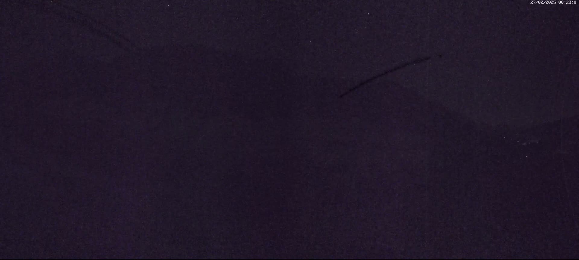 A dark purple or black textured surface shows two faint, thin, diagonal scratch marks.