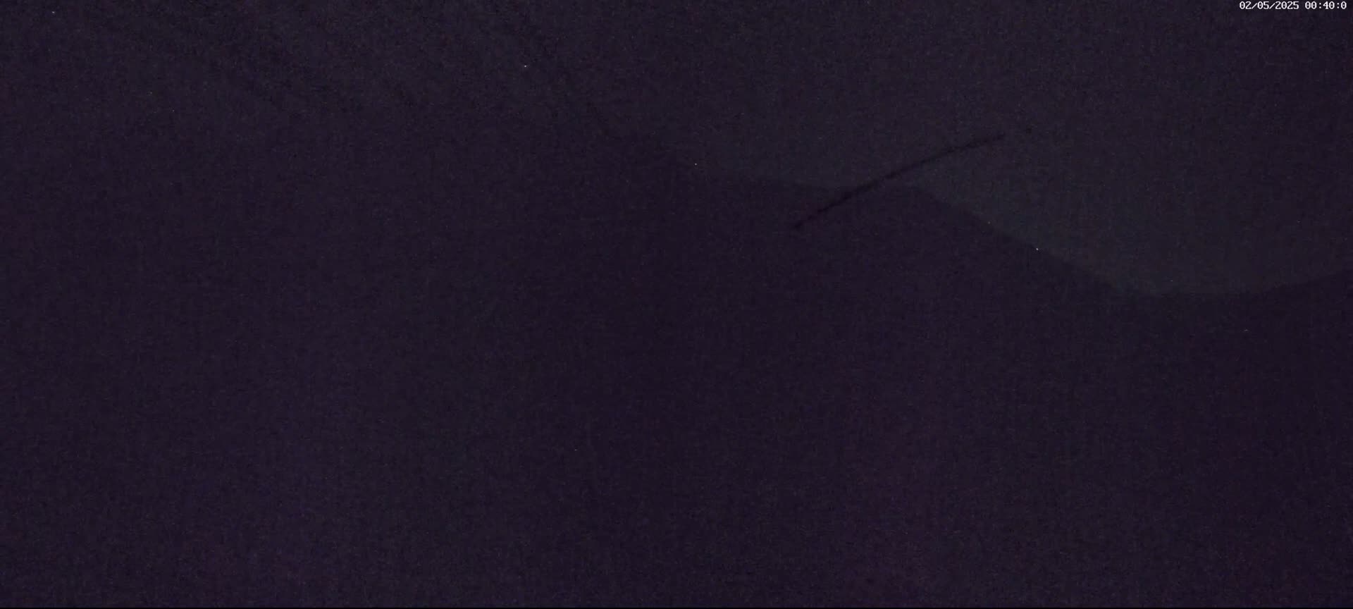 A dark, nighttime image shows a mostly featureless, dark-purple sky.