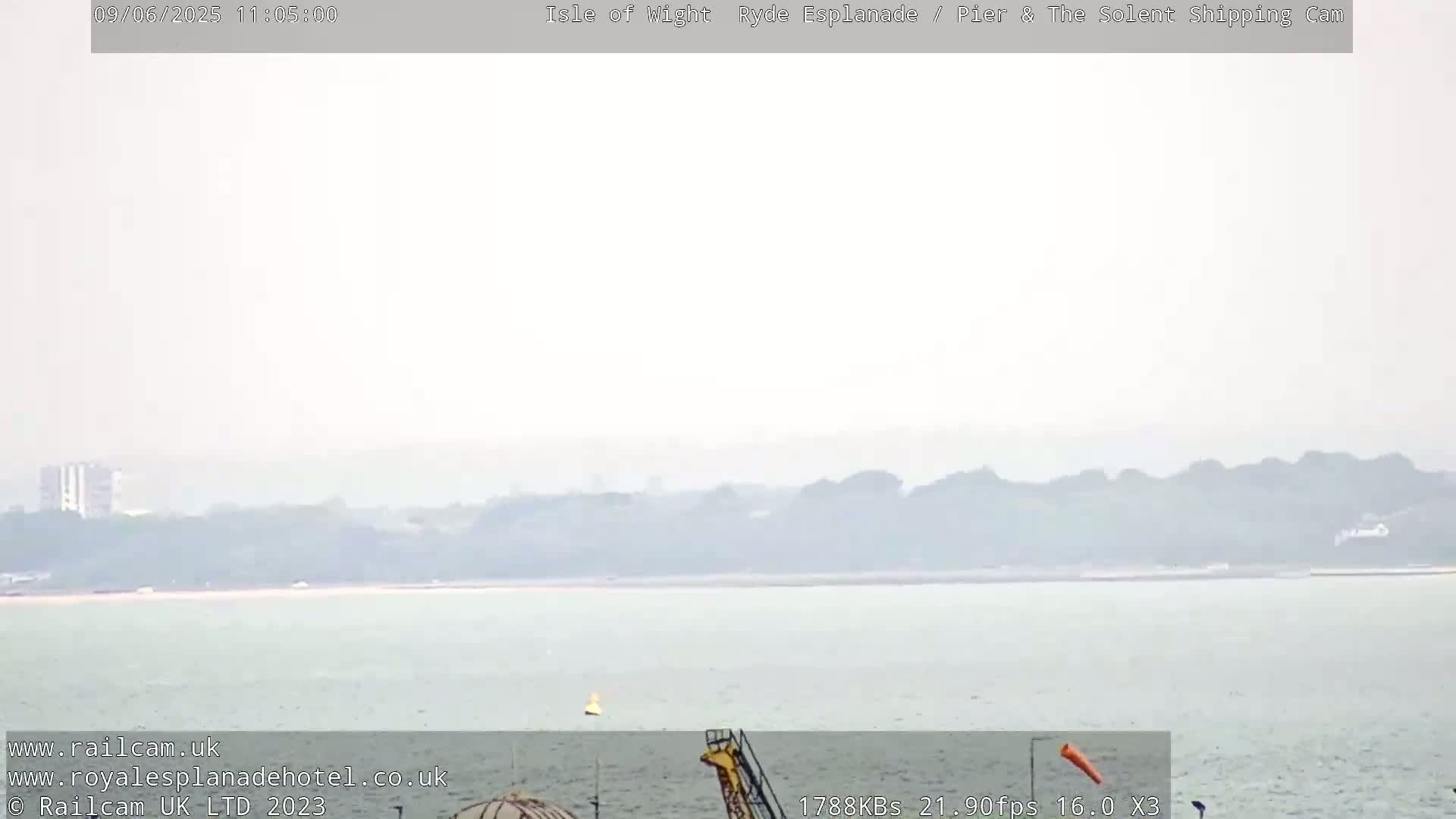A hazy, overcast view of a calm body of water with a distant shoreline.