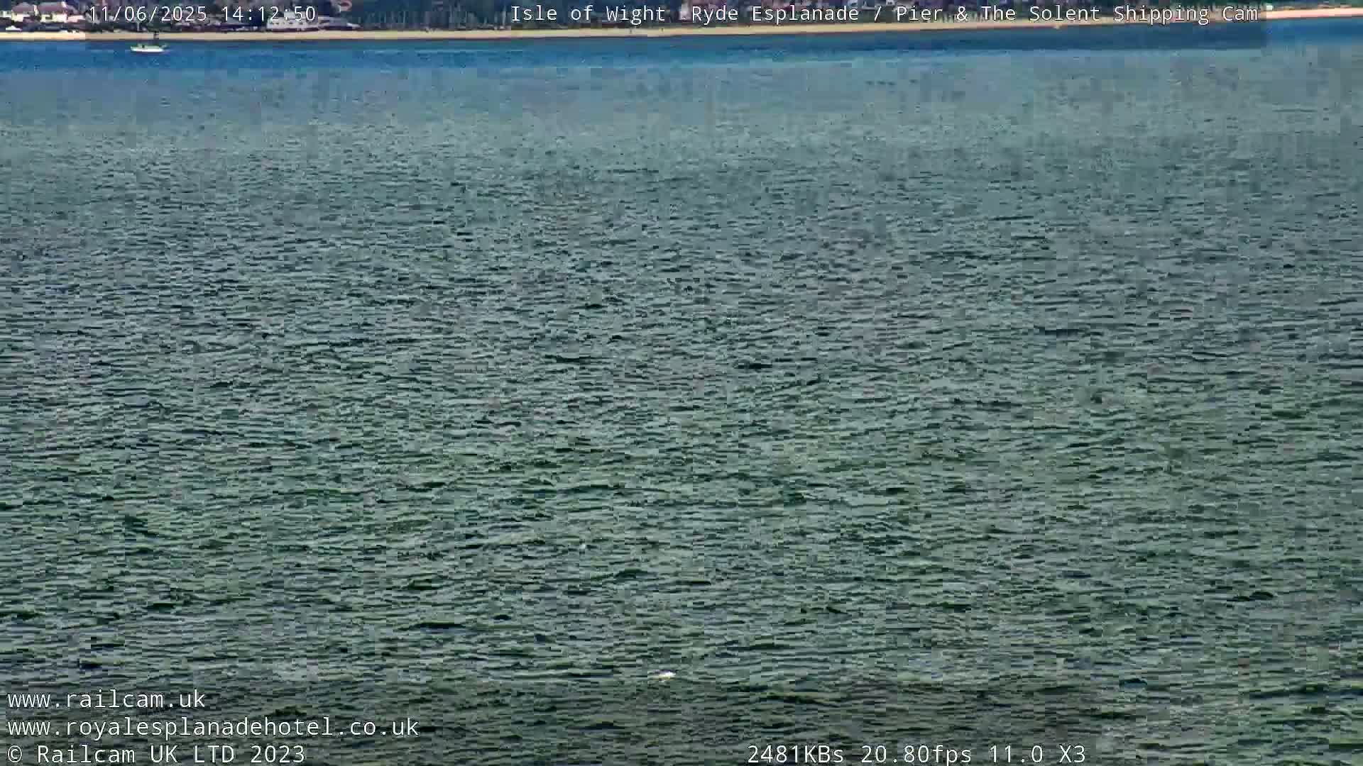 A calm body of water with a small boat in the distance.