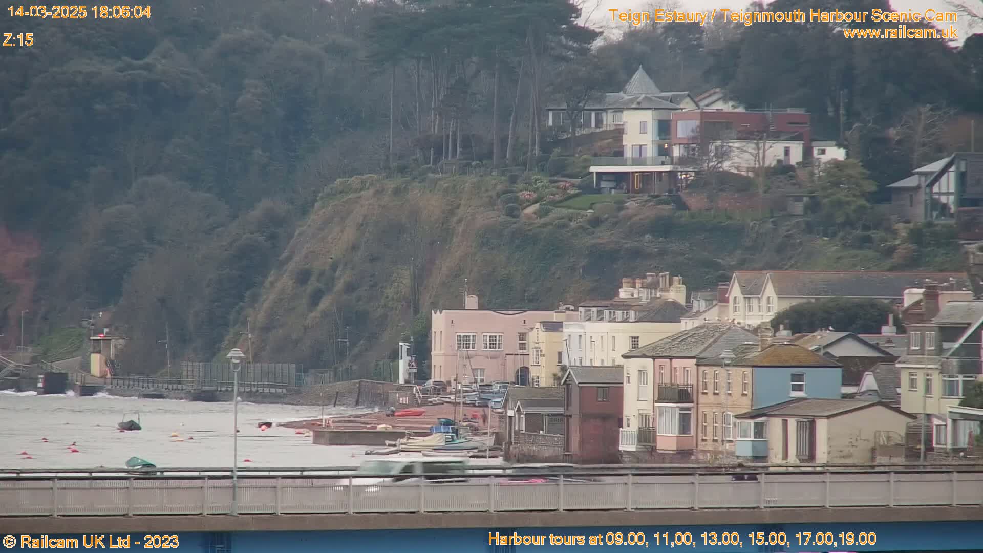 A coastal town with colorful houses sits beside a choppy gray sea under an overcast sky.