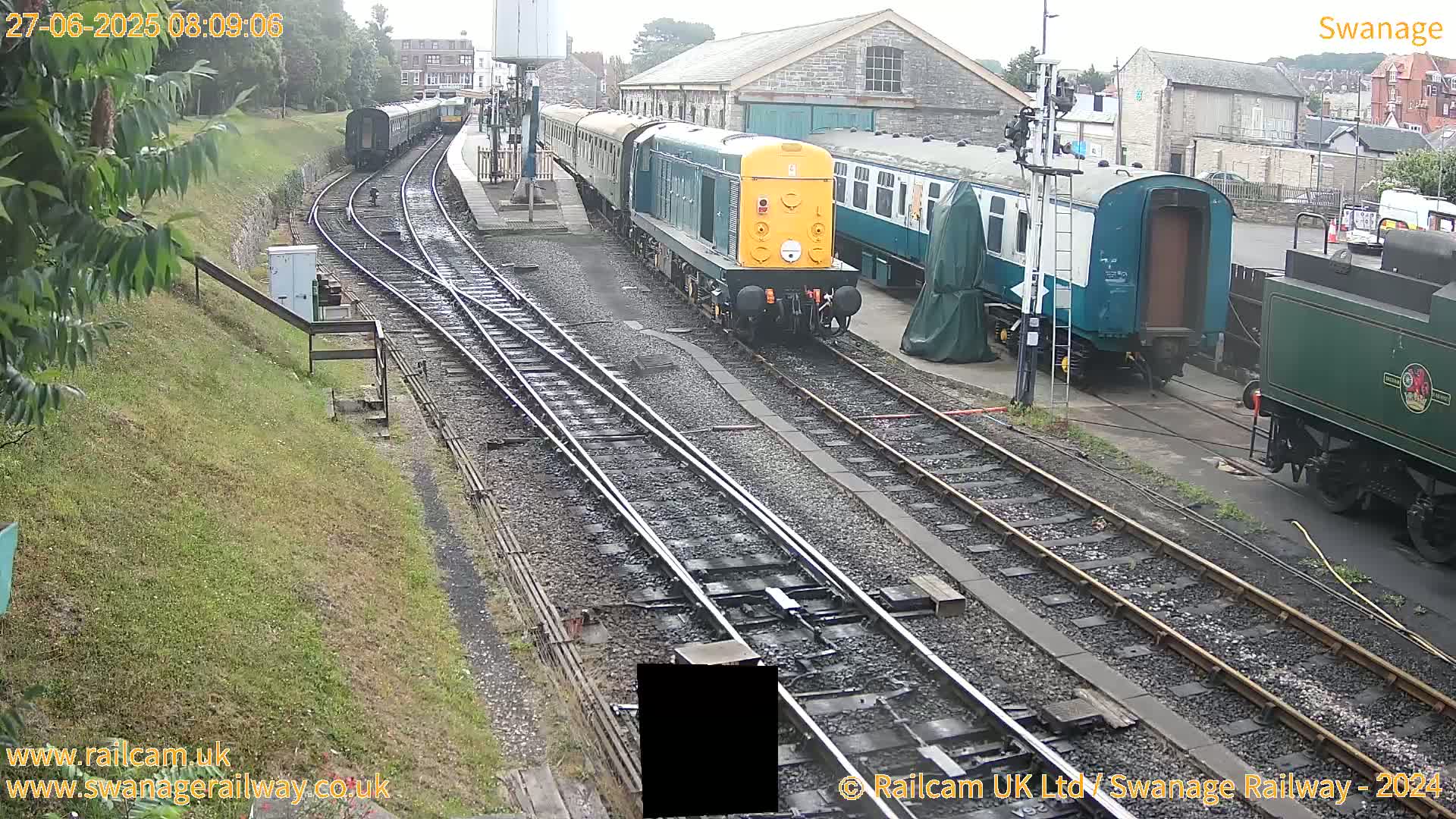 Several railway carriages and locomotives are parked on a railway track in overcast weather.