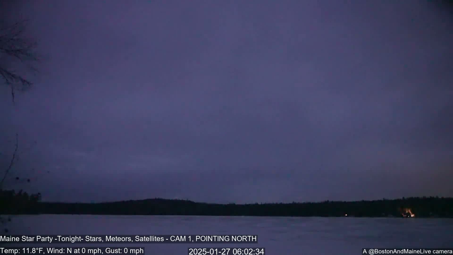 A calm, dark, pre-dawn sky over a frozen lake and distant trees is shown.