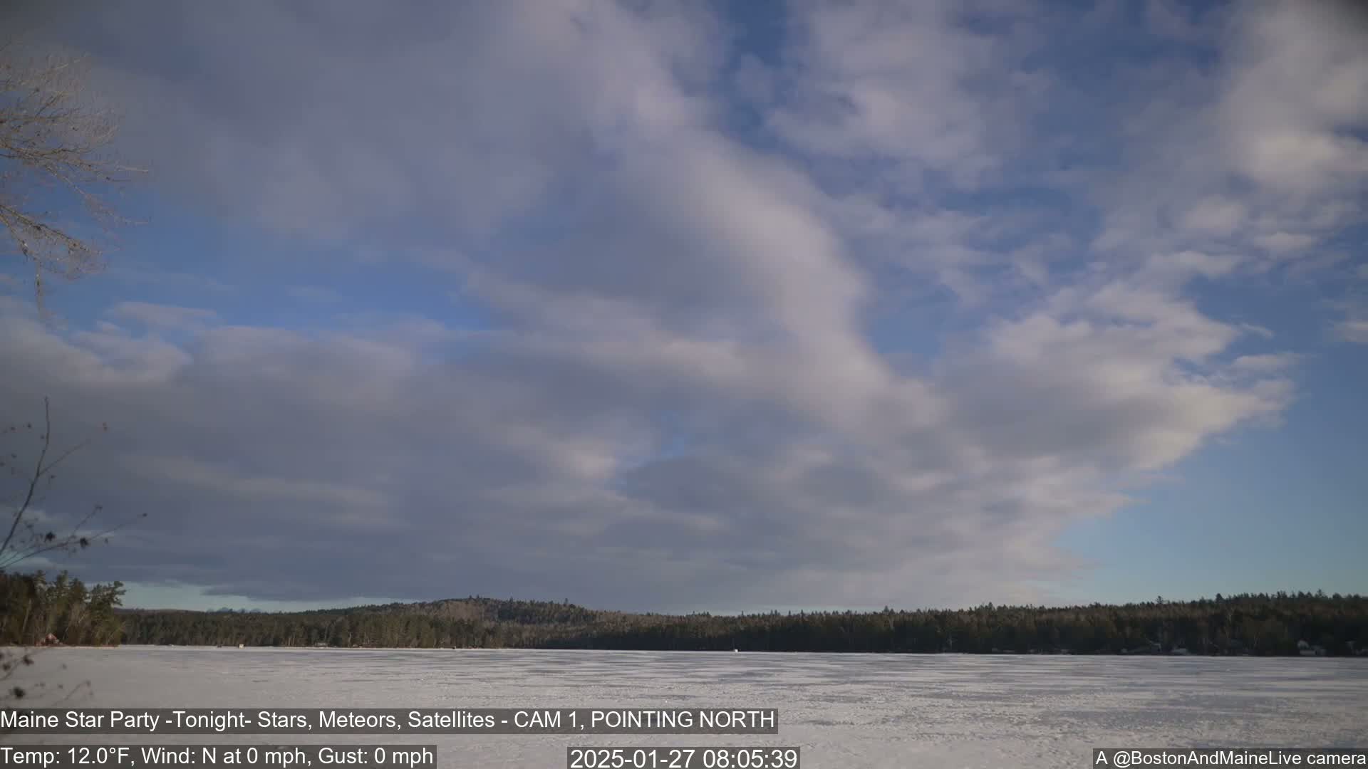 A frozen lake is visible under a mostly cloudy sky.