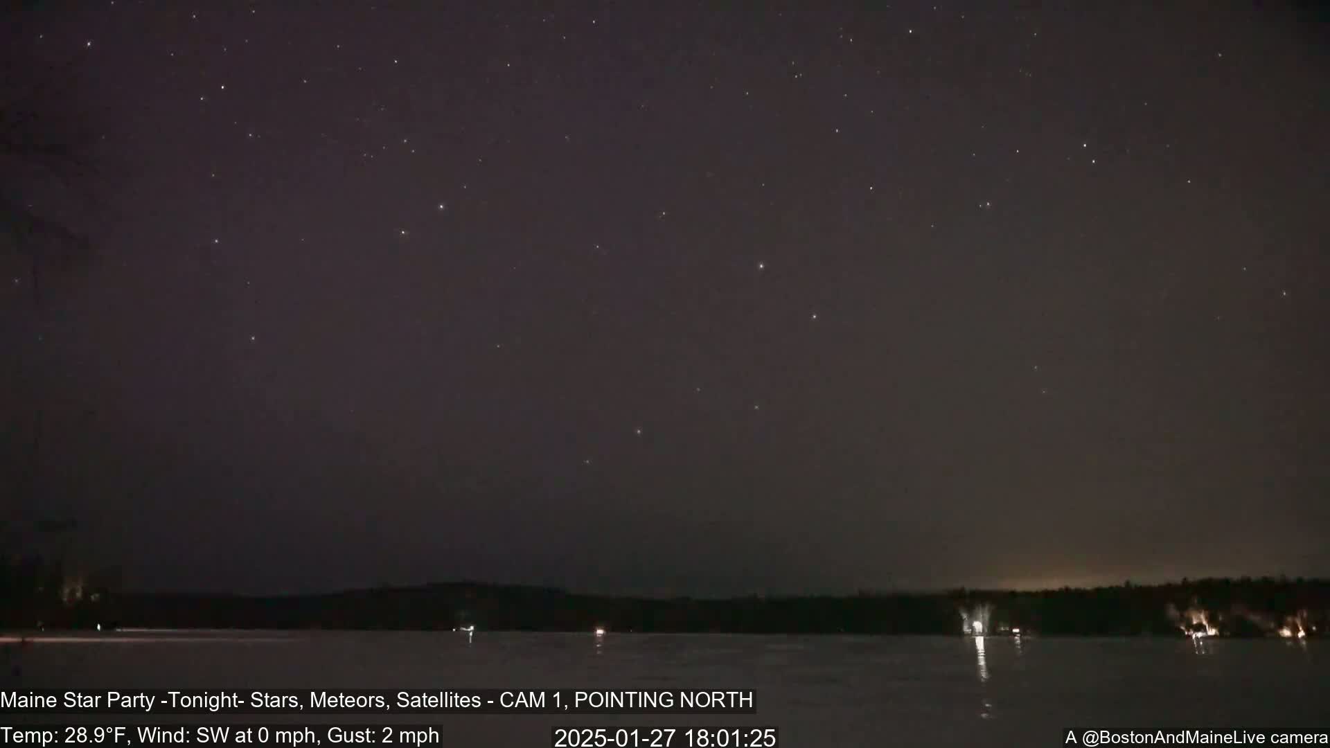 A nighttime view of a starry sky over a frozen lake, with a calm wind.