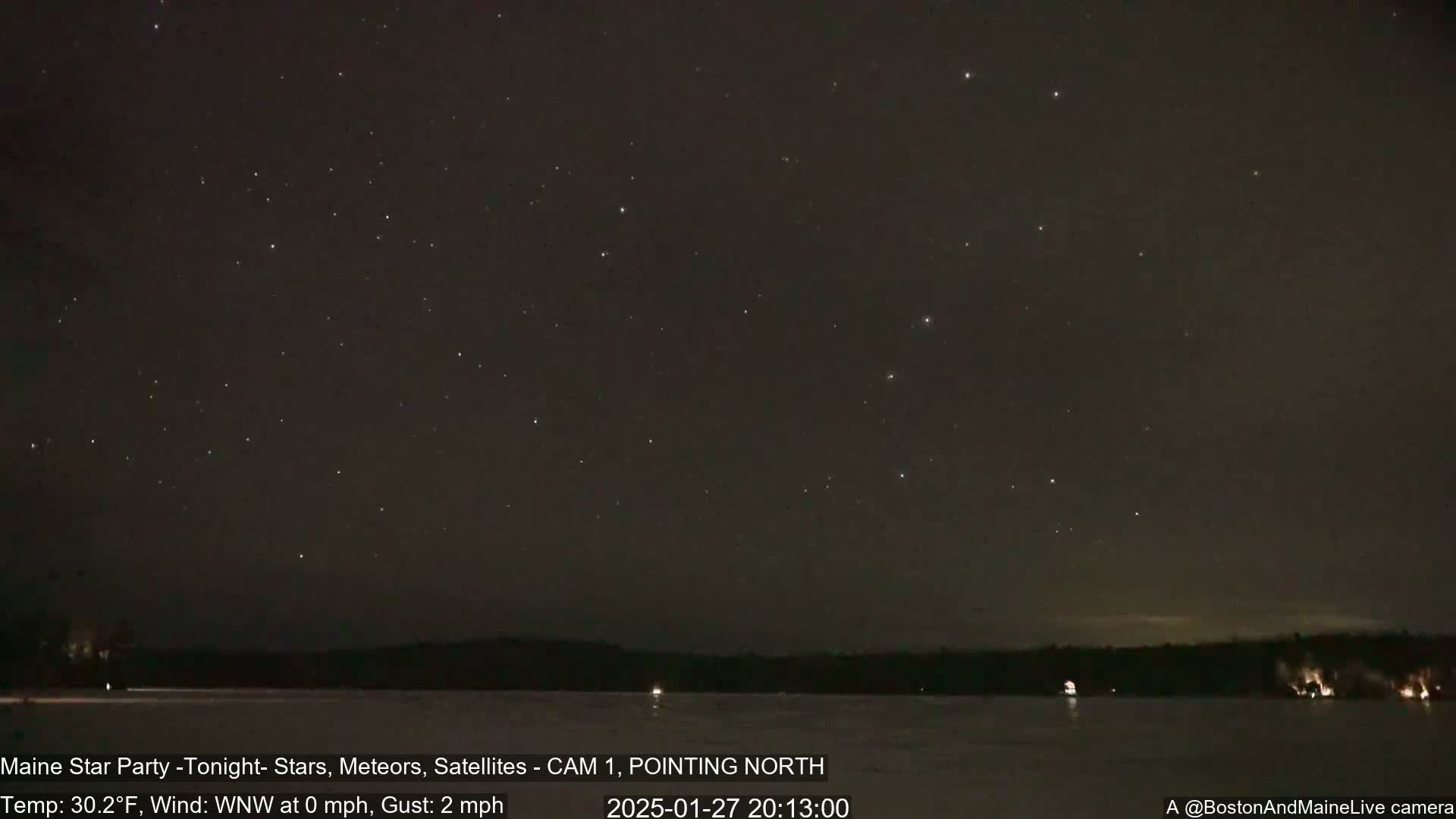 A nighttime long shot shows a clear, starry sky over a dark, snow-covered lake and treeline, with a calm wind.