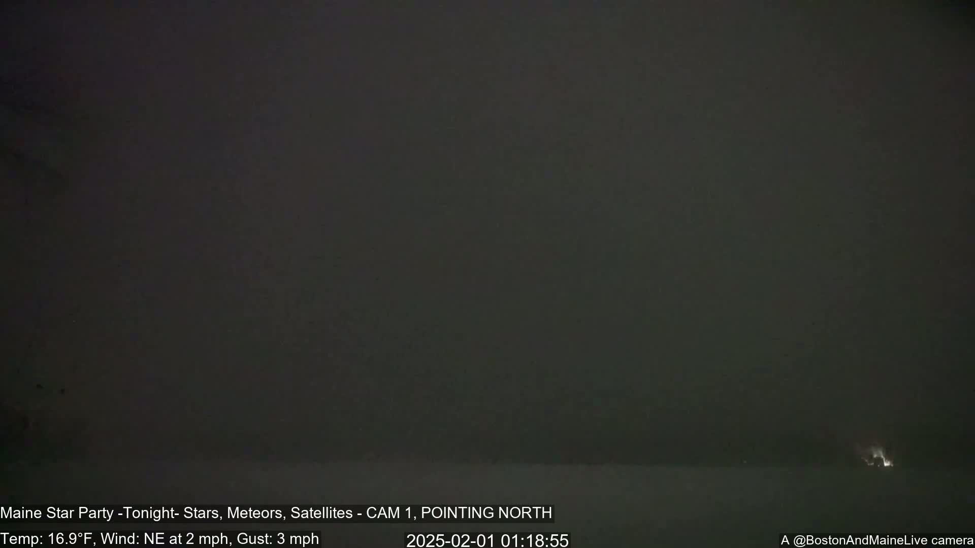 A dark, nighttime outdoor scene with a mostly overcast sky and a faint light source in the distance.