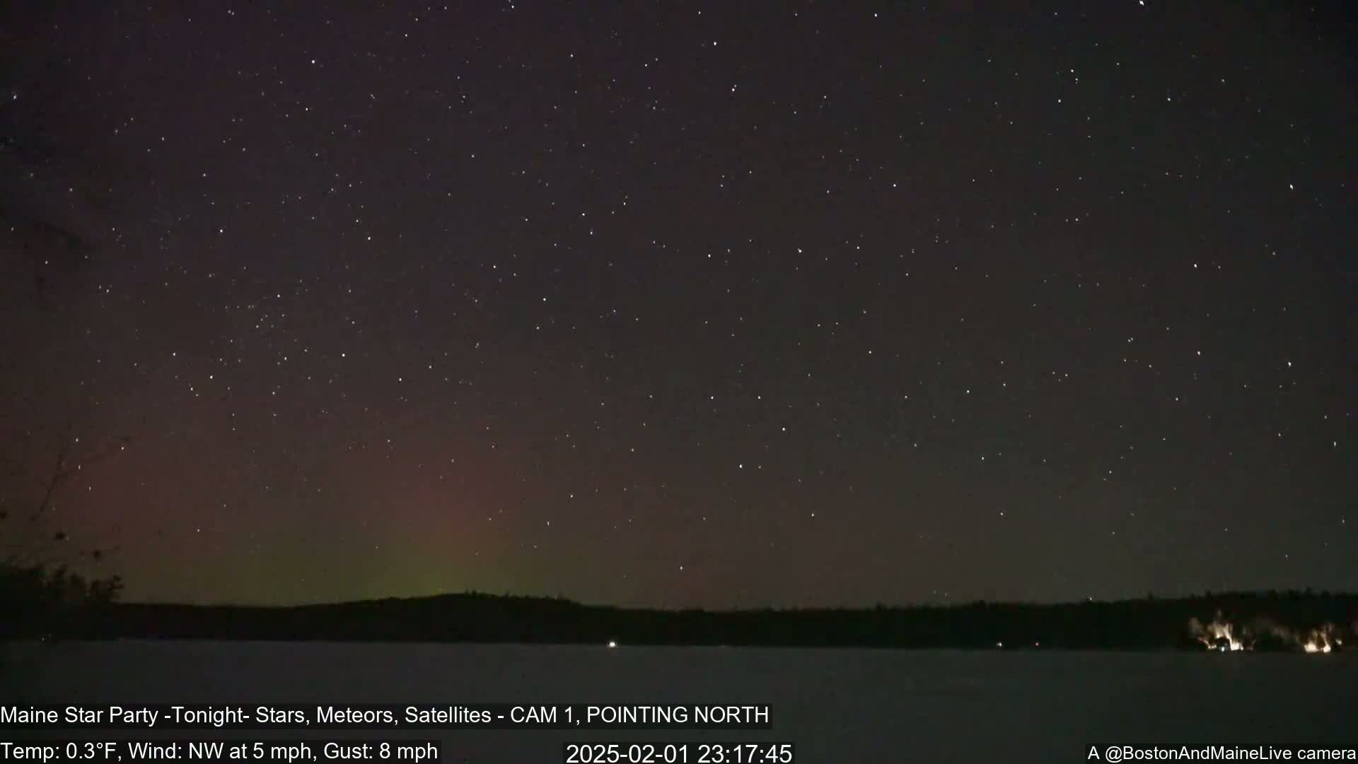 A nighttime scene shows a starry sky with a faint aurora borealis over a dark, snow-covered landscape, under a 0.3°F temperature with a northwest wind at 5 mph and gusts up to 8 mph.