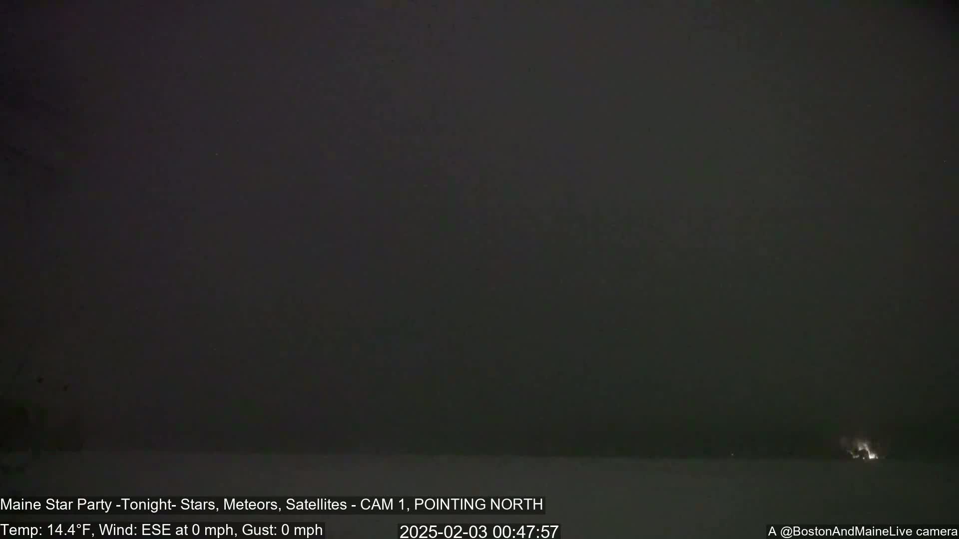 A dark, nighttime outdoor scene with a calm, clear sky shows a faint light source on the horizon.