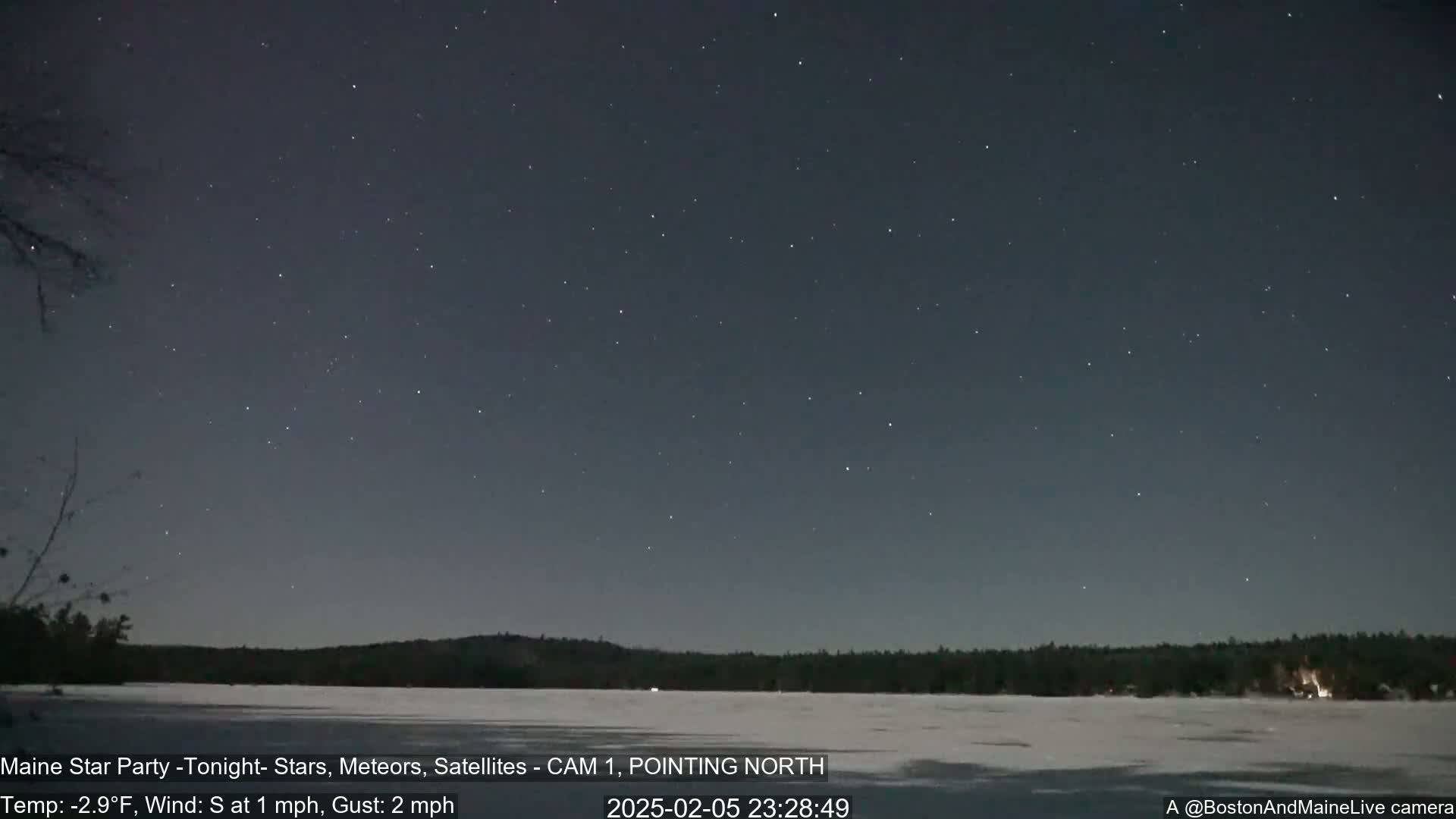 A nighttime long shot shows a dark, starry sky over a frozen lake and a dark treeline, with a light south wind and a temperature of -2.9°F.