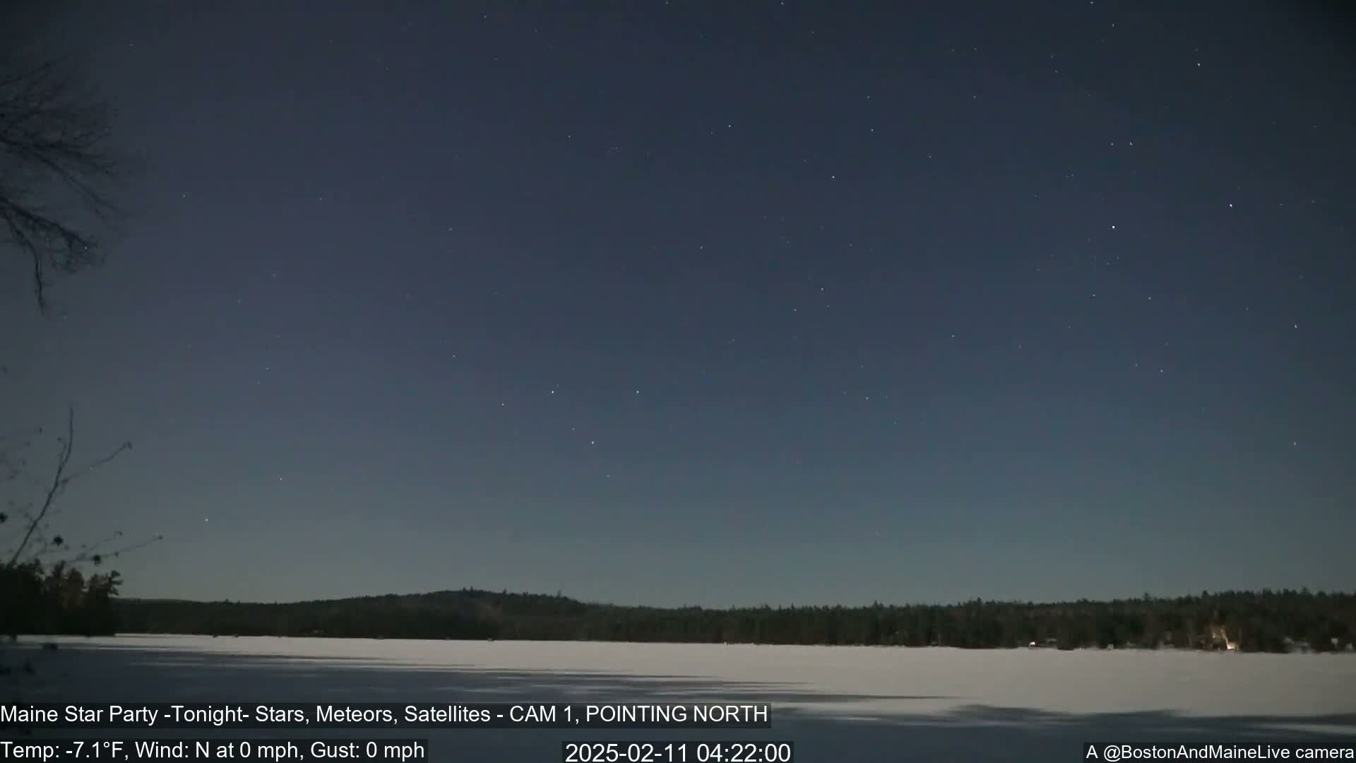 A frozen lake is visible under a dark, clear night sky dotted with stars, with a calm wind and a temperature of -7.1°F.