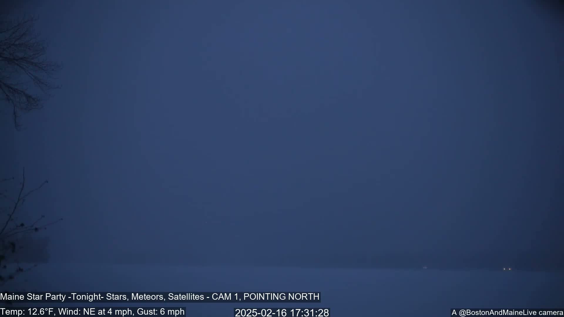 A dark, snowy, and hazy scene is visible at night with a few distant lights.