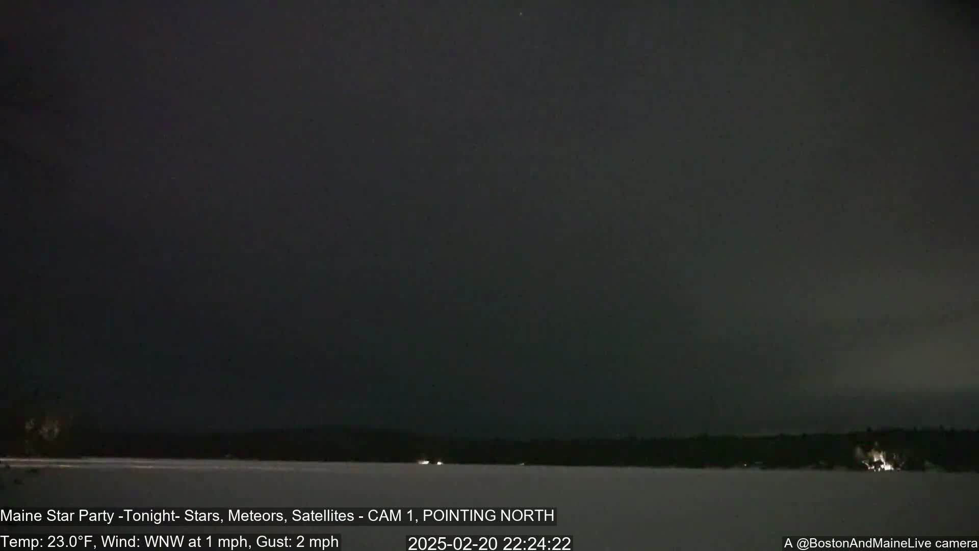A nighttime, snowy landscape is visible under a dark sky with a slight wind from the west-northwest at 1 mph, gusting to 2 mph and a temperature of 23 degrees Fahrenheit.
