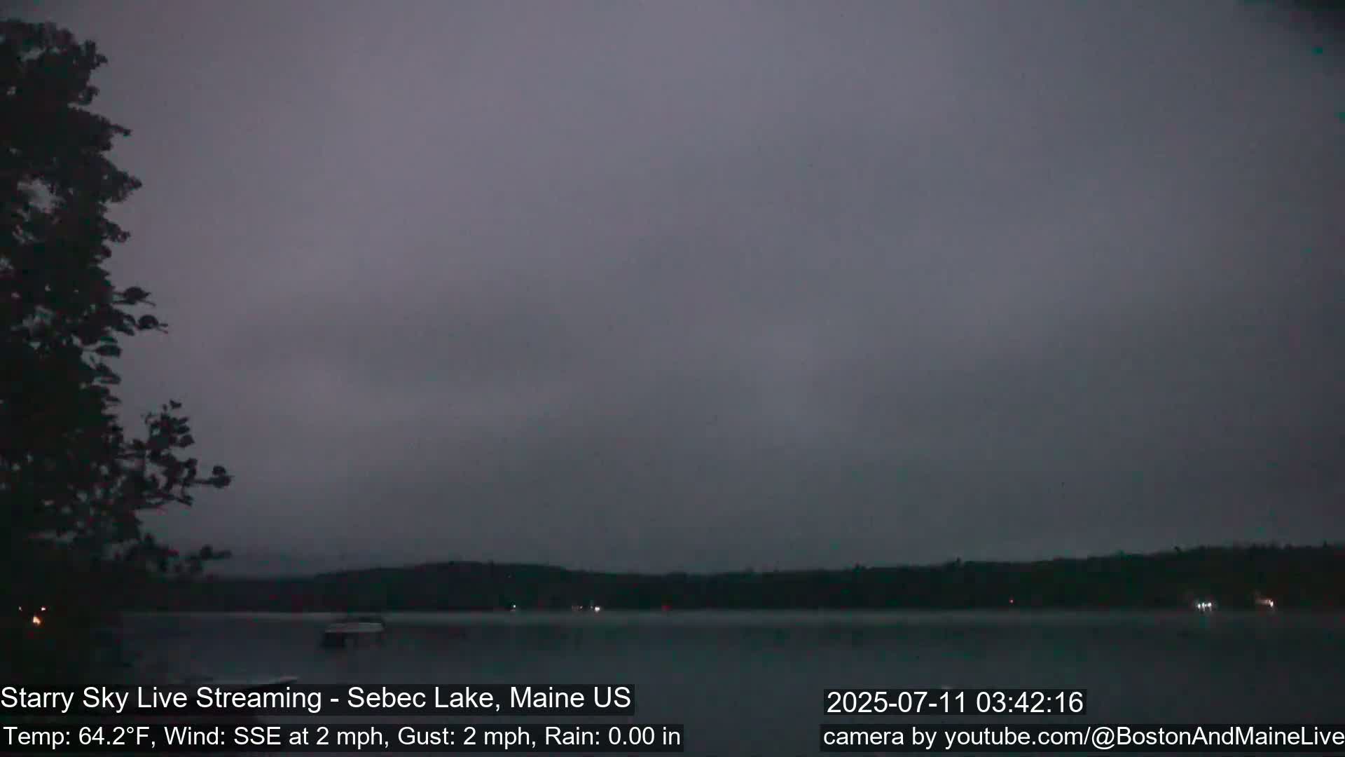 A dark, overcast view of a lake at dusk, with a slight wind.