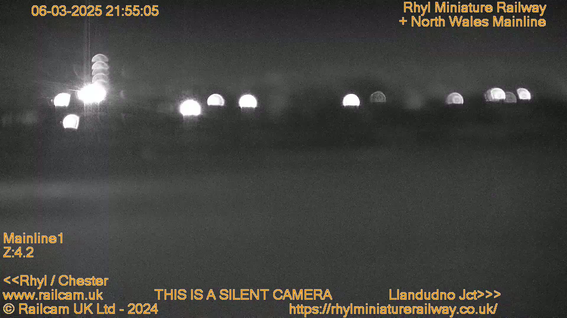 At night, several distant lights are visible, possibly headlights of vehicles or trains.