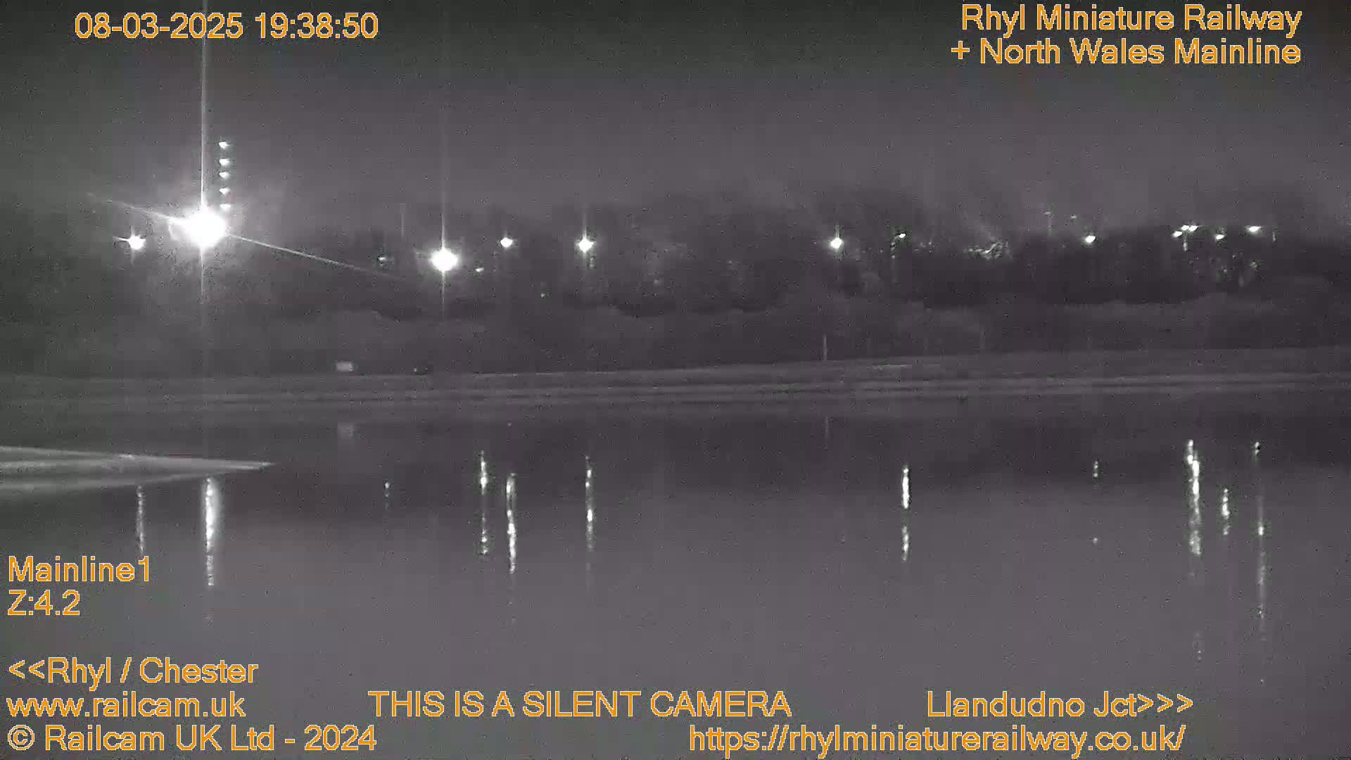 A nighttime view of a calm body of water reflecting lights from a distant shoreline.