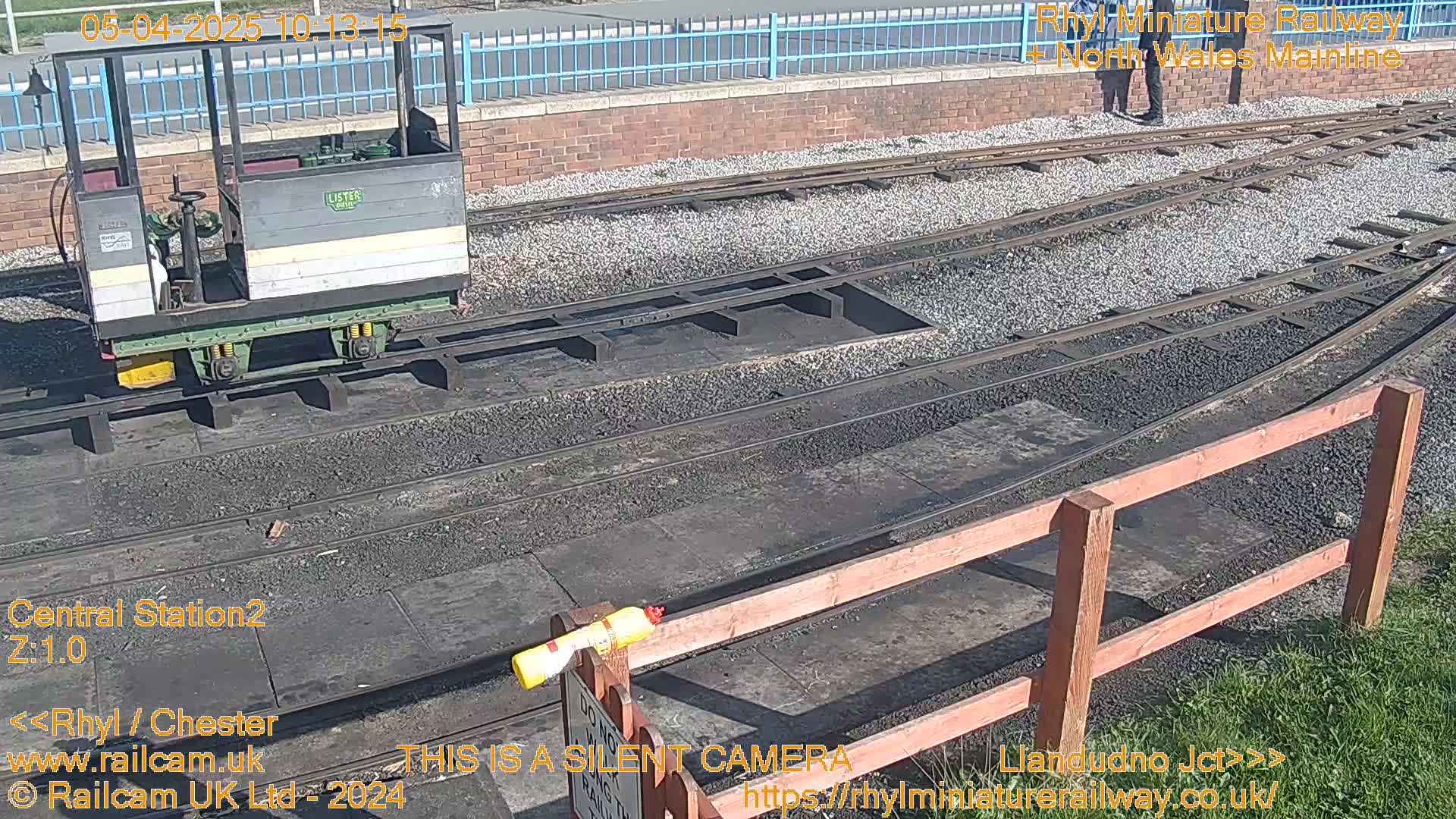 A small railway car sits on a set of tracks on a sunny day.