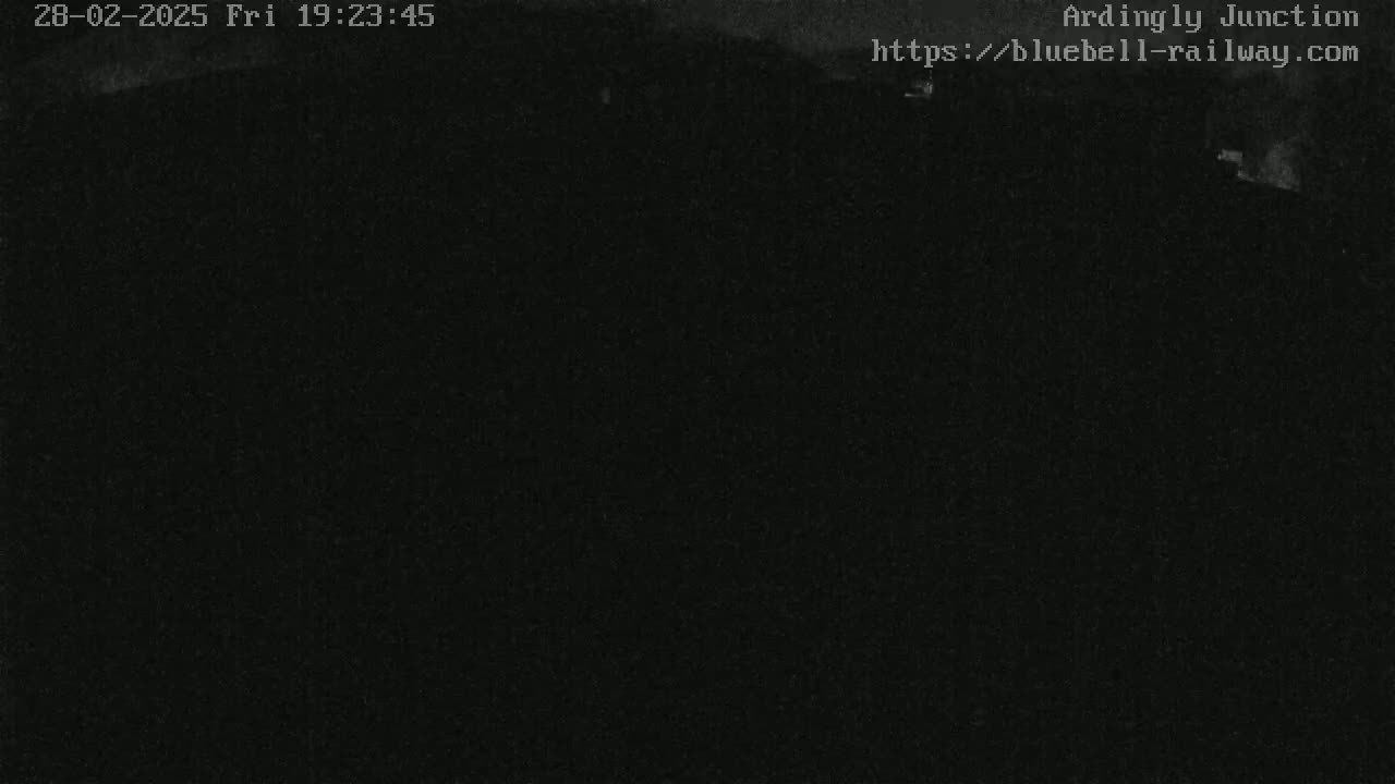 A dark, nighttime outdoor scene is shown, appearing mostly black with indistinct shapes.